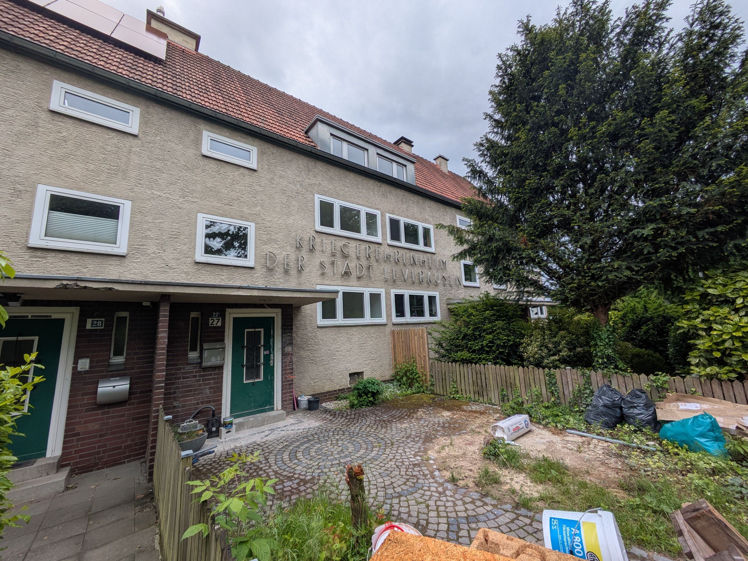 Baumaterial liegt vor einem Wohnhaus.