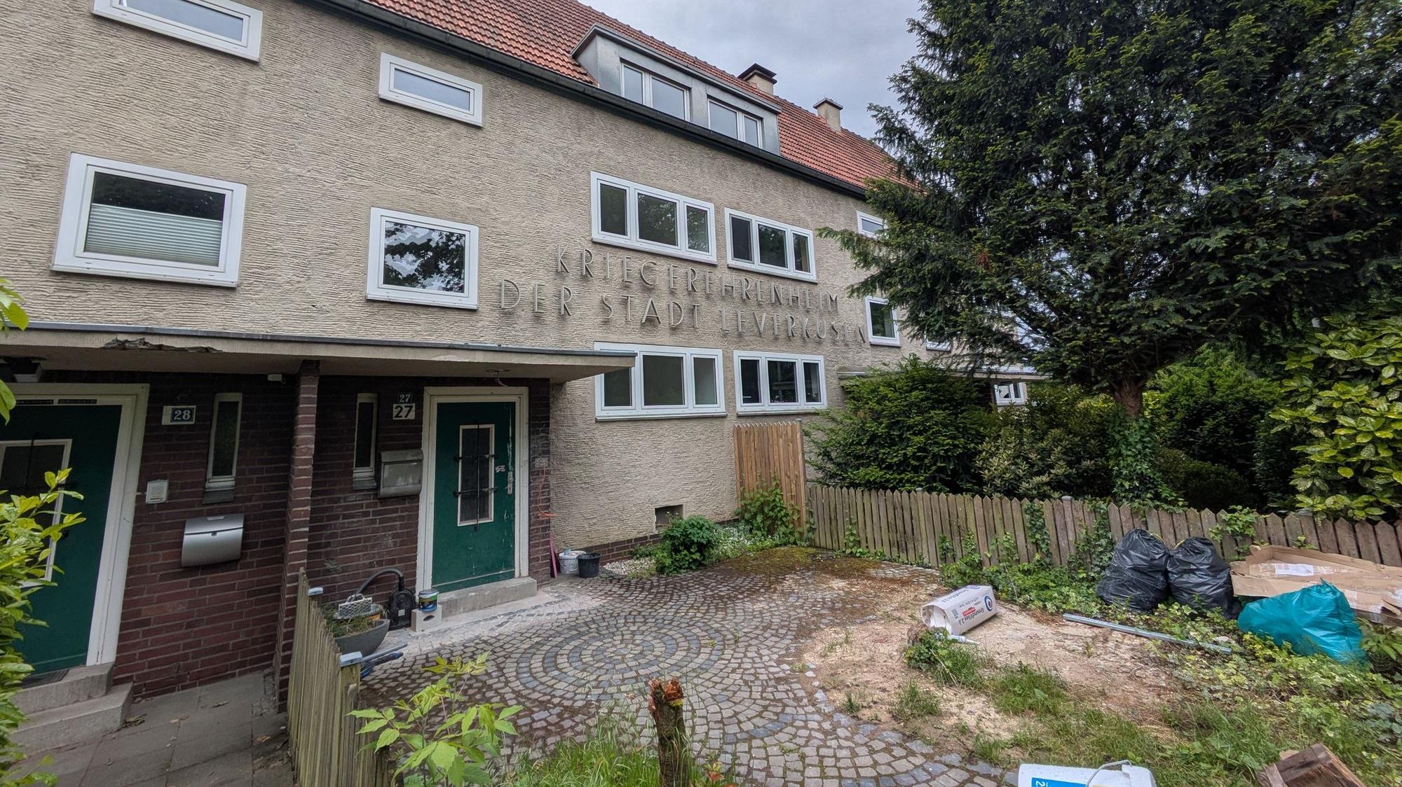 Baumaterial liegt vor einem Wohnhaus.