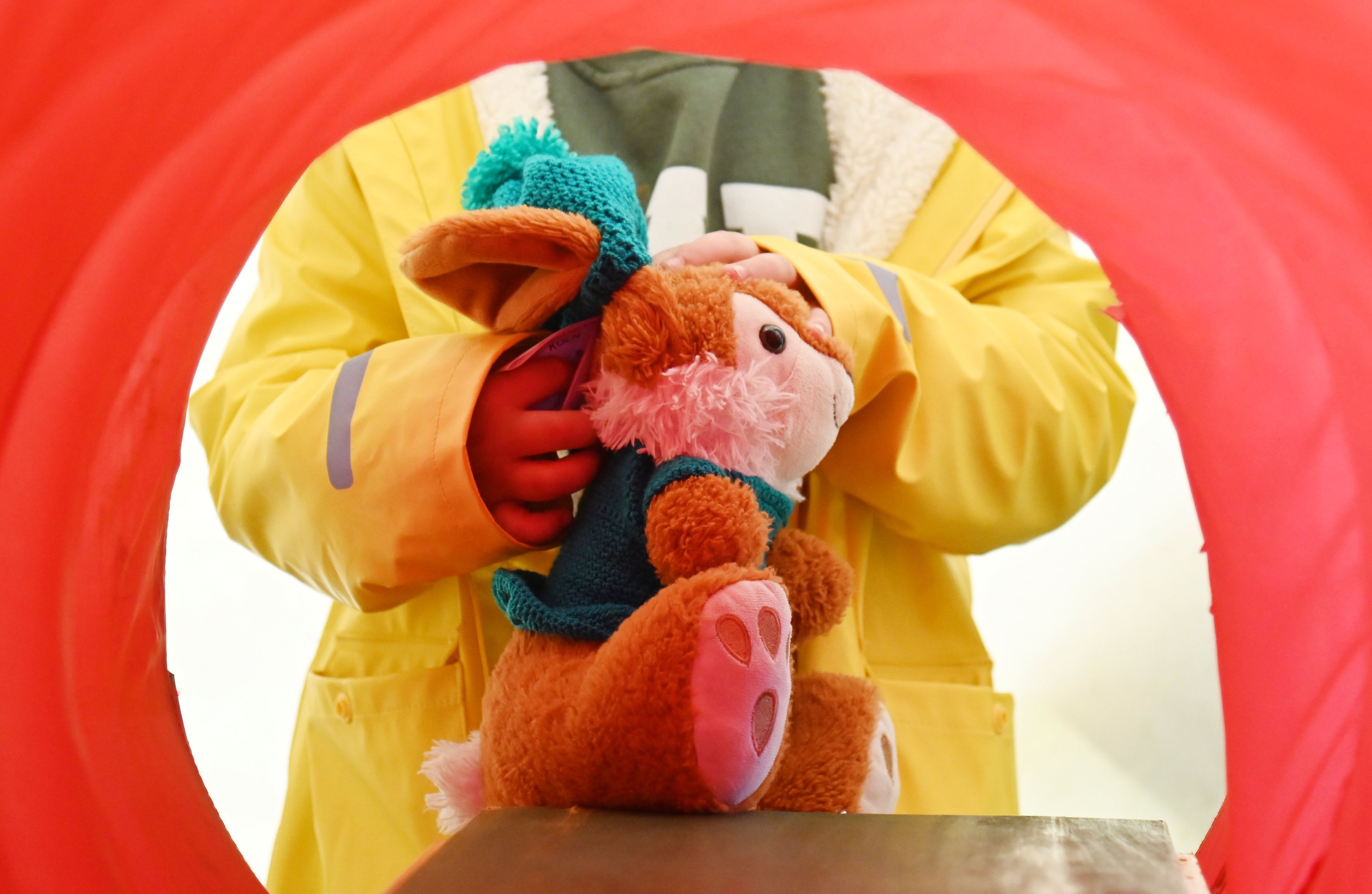 Kuscheltier Hase wird zum Röntgen in Stoffröhre geschoben.