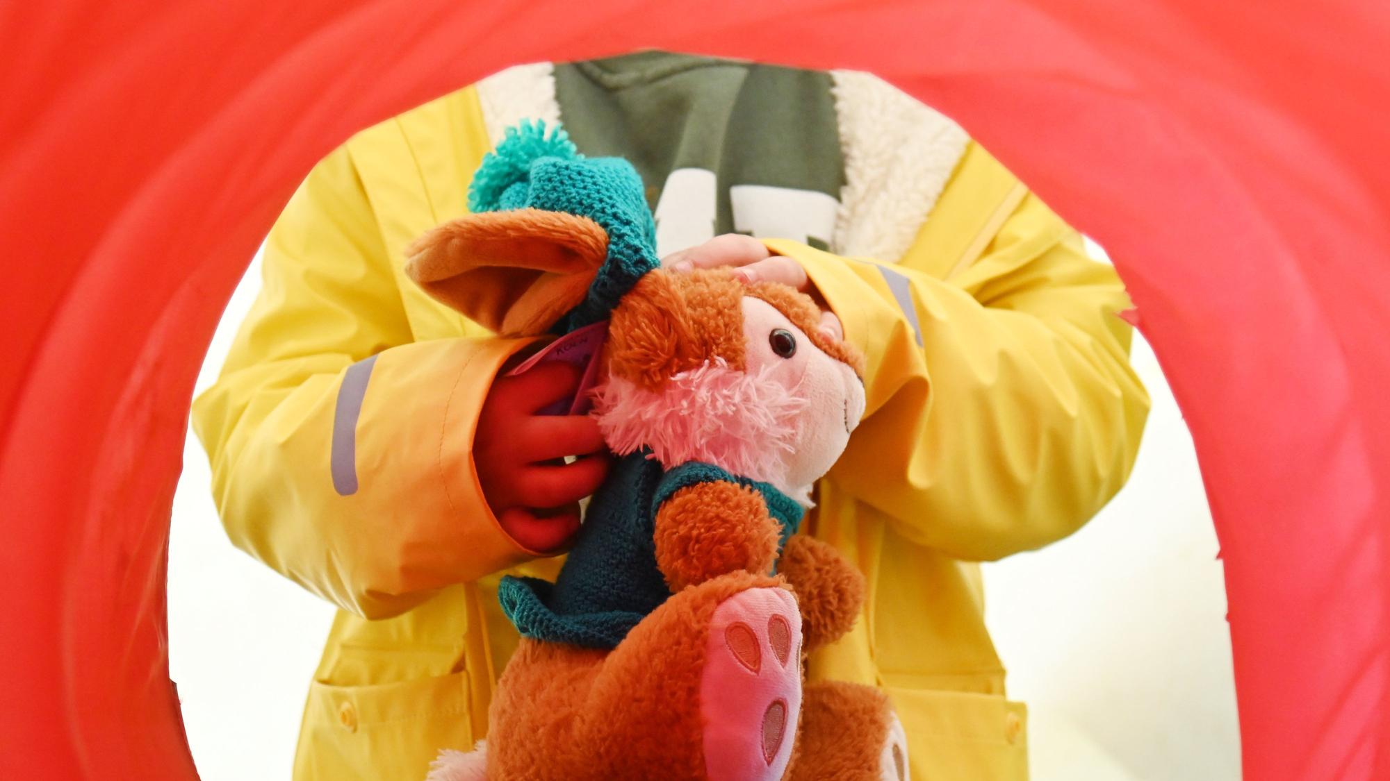Kuscheltier Hase wird zum Röntgen in Stoffröhre geschoben.