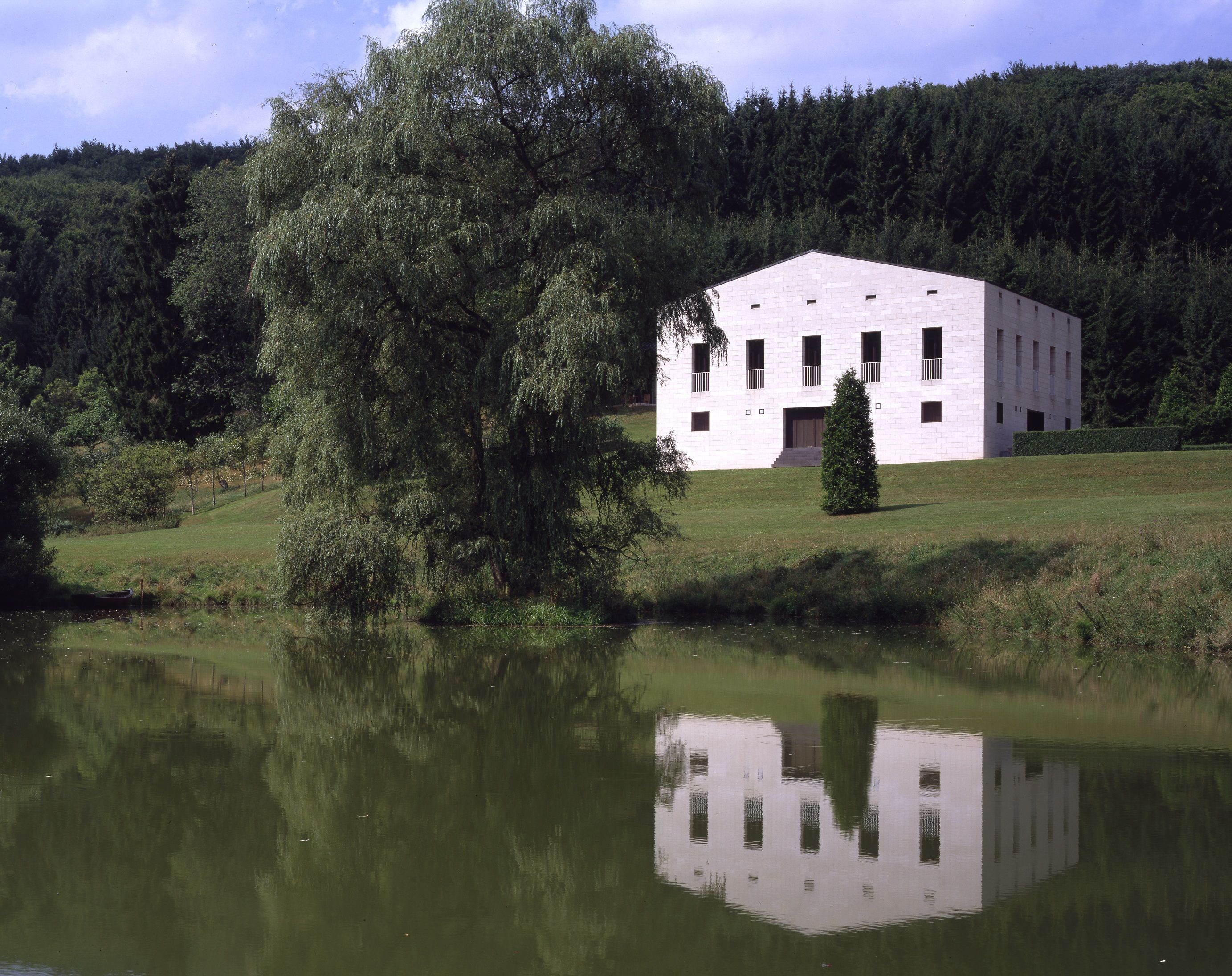 Ein Haus spiegelt sich in einem Teich.