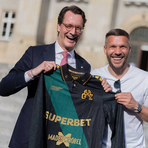 Lukas Podolski (r.), ehemaliger Fußball-Nationalspieler und Spieler beim polnischen Erstligisten Górnik Zabrze, überreicht Hendrik Wüst (CDU), Ministerpräsident von Nordrhein-Westfalen, ein Trikot.