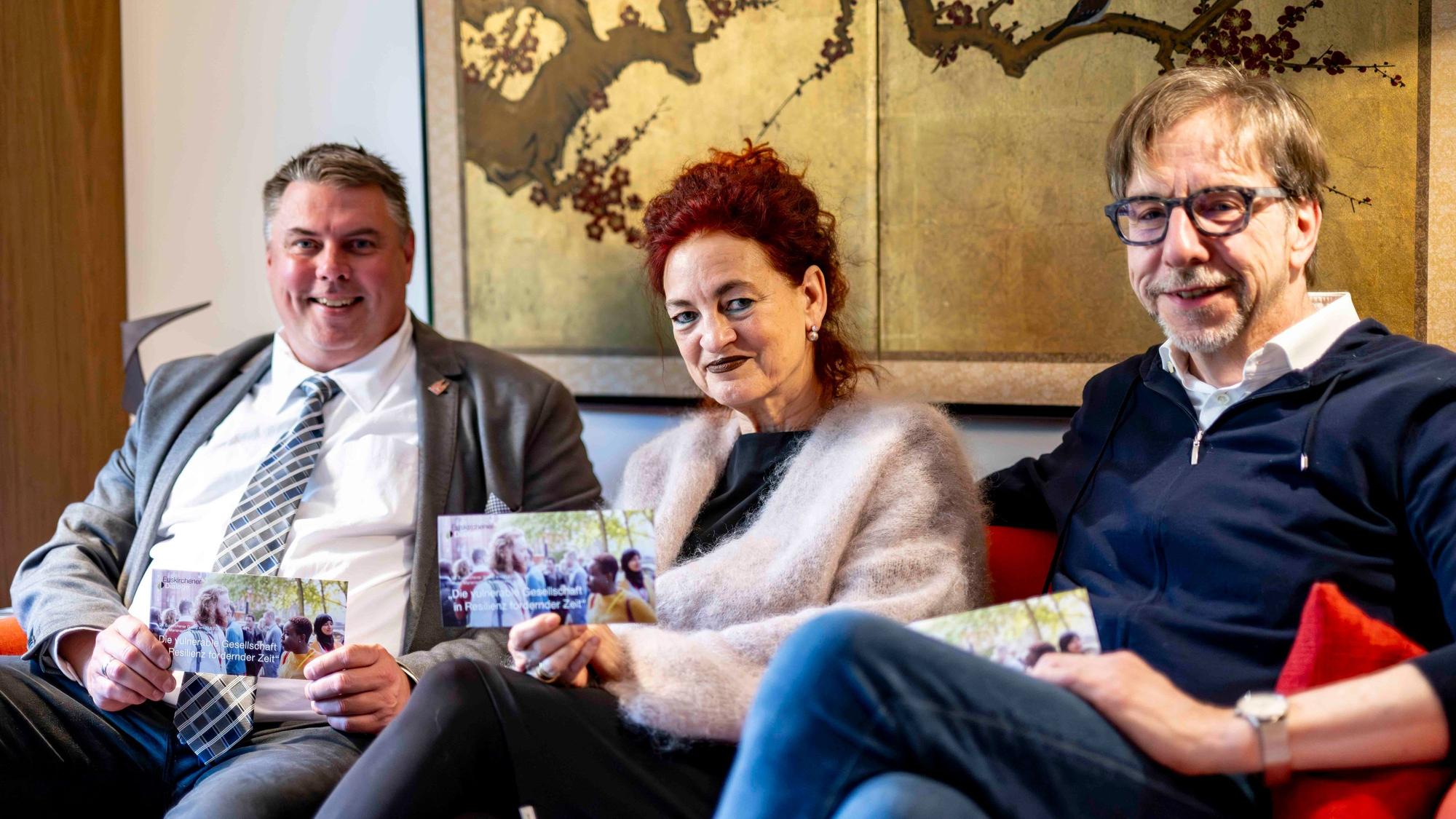 Michael Mombaur (l.), Dr. Ulrike Bardt und Dr. Hubertus Rüber sitzen auf einem Sofa.