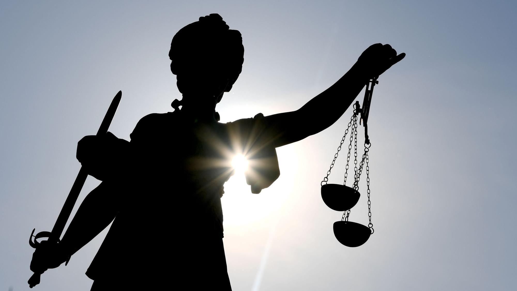 Die Göttin Justitia im Gegenlicht auf dem Gerechtigkeitsbrunnen in Frankfurt am Main.