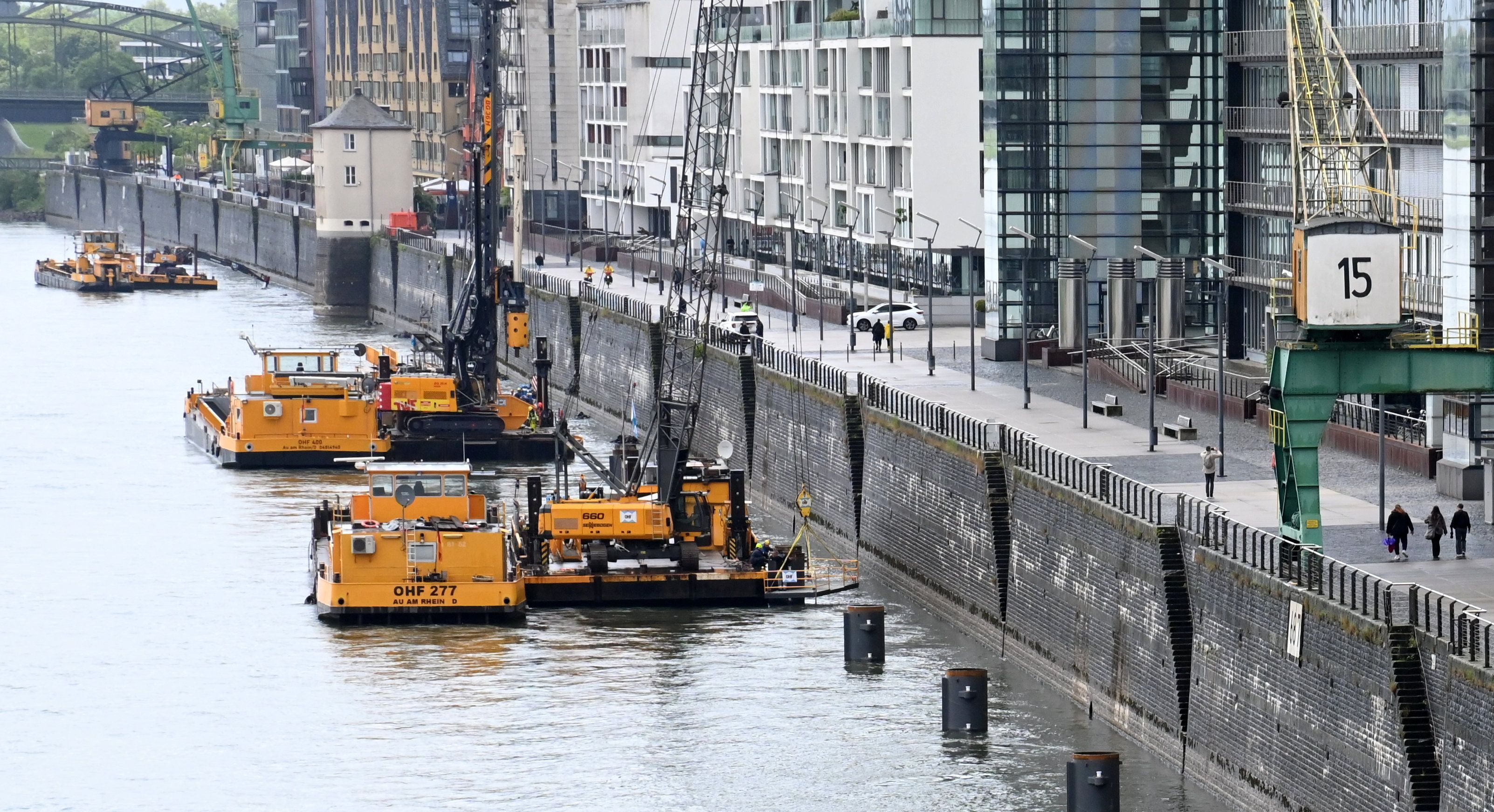 Arbeitsschiffe einer Wasserbaufirma liegen vor der Kaimauer des Kölner Rheinauhafens