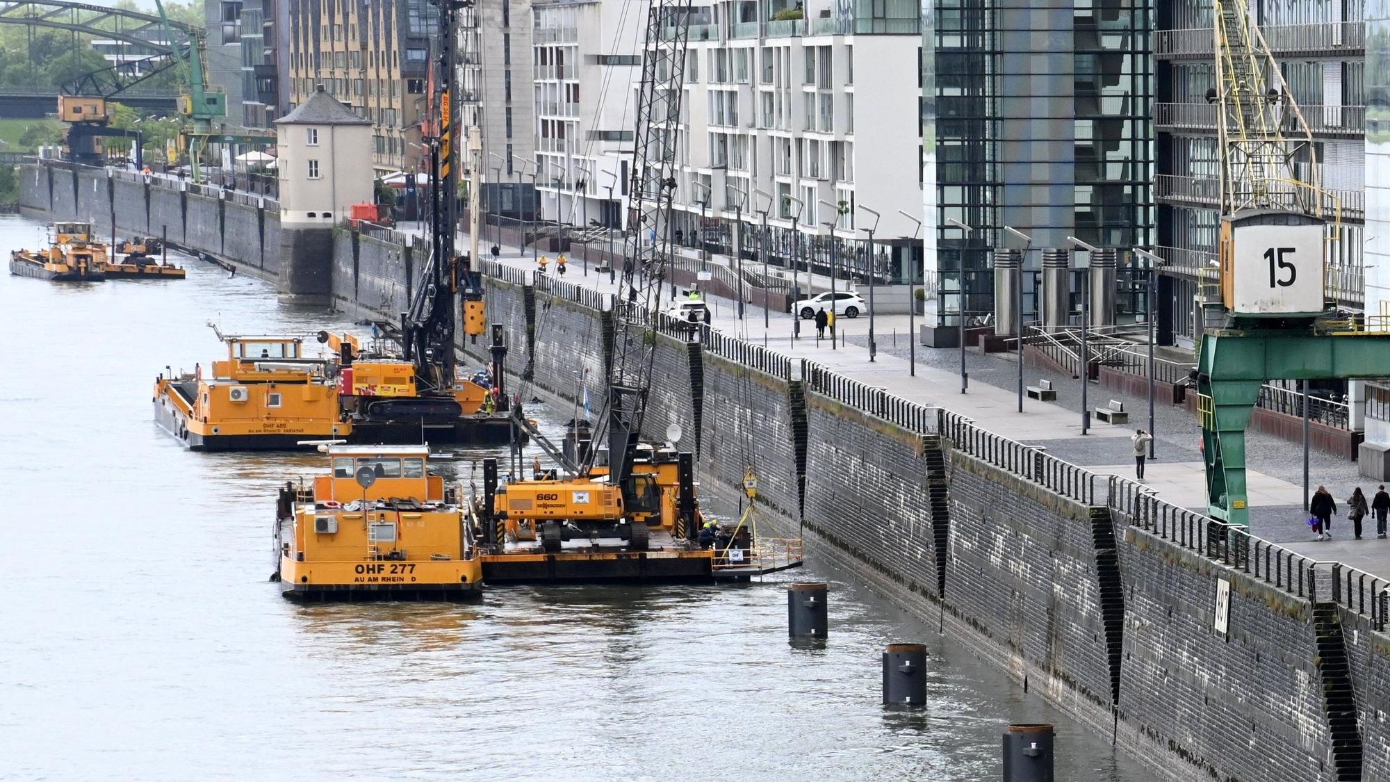 Arbeitsschiffe einer Wasserbaufirma liegen vor der Kaimauer des Kölner Rheinauhafens