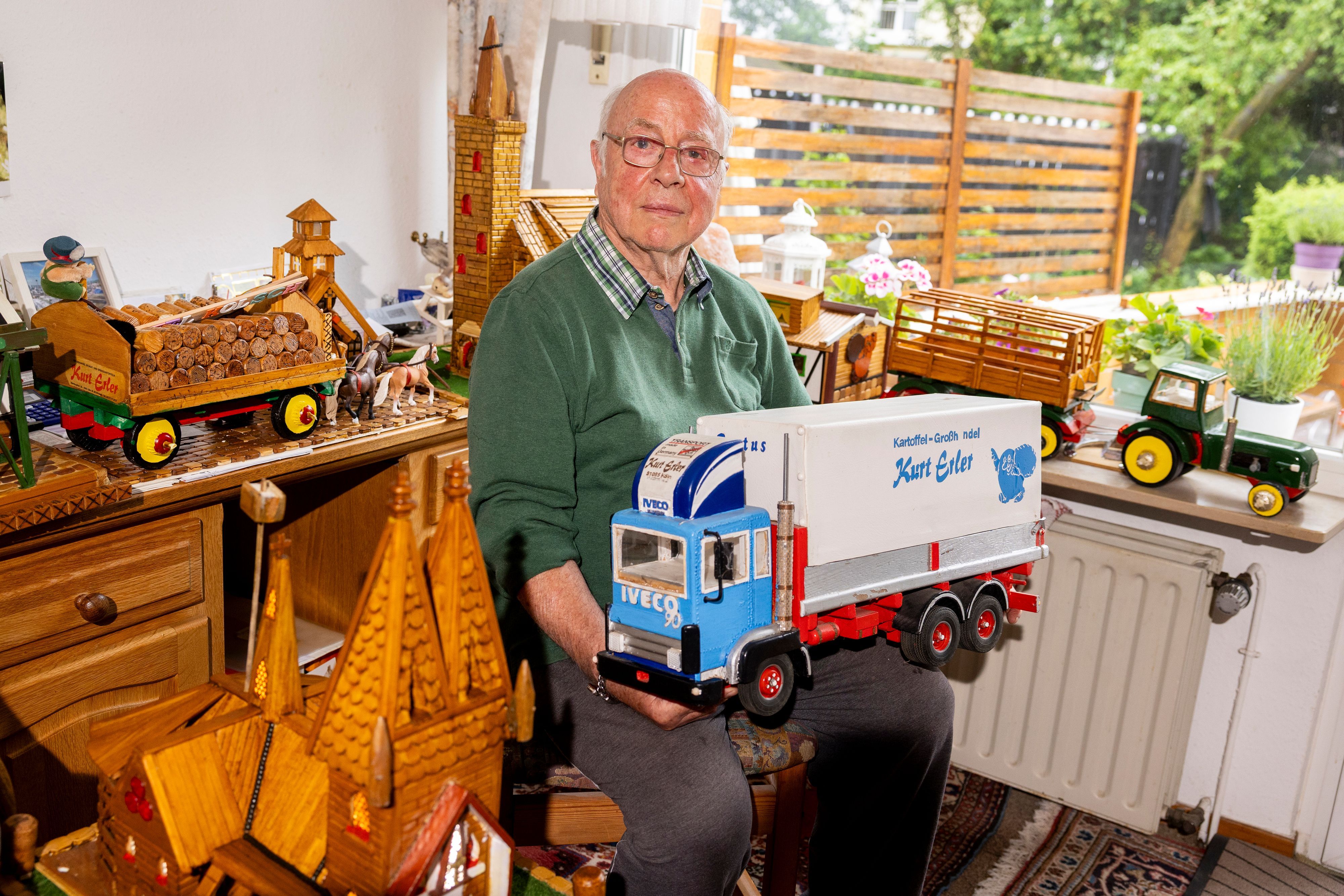 Kurt Erler (88) mit dem Modell seines Lastwagens und den vielen Holzmodellen, die er gebaut hat.