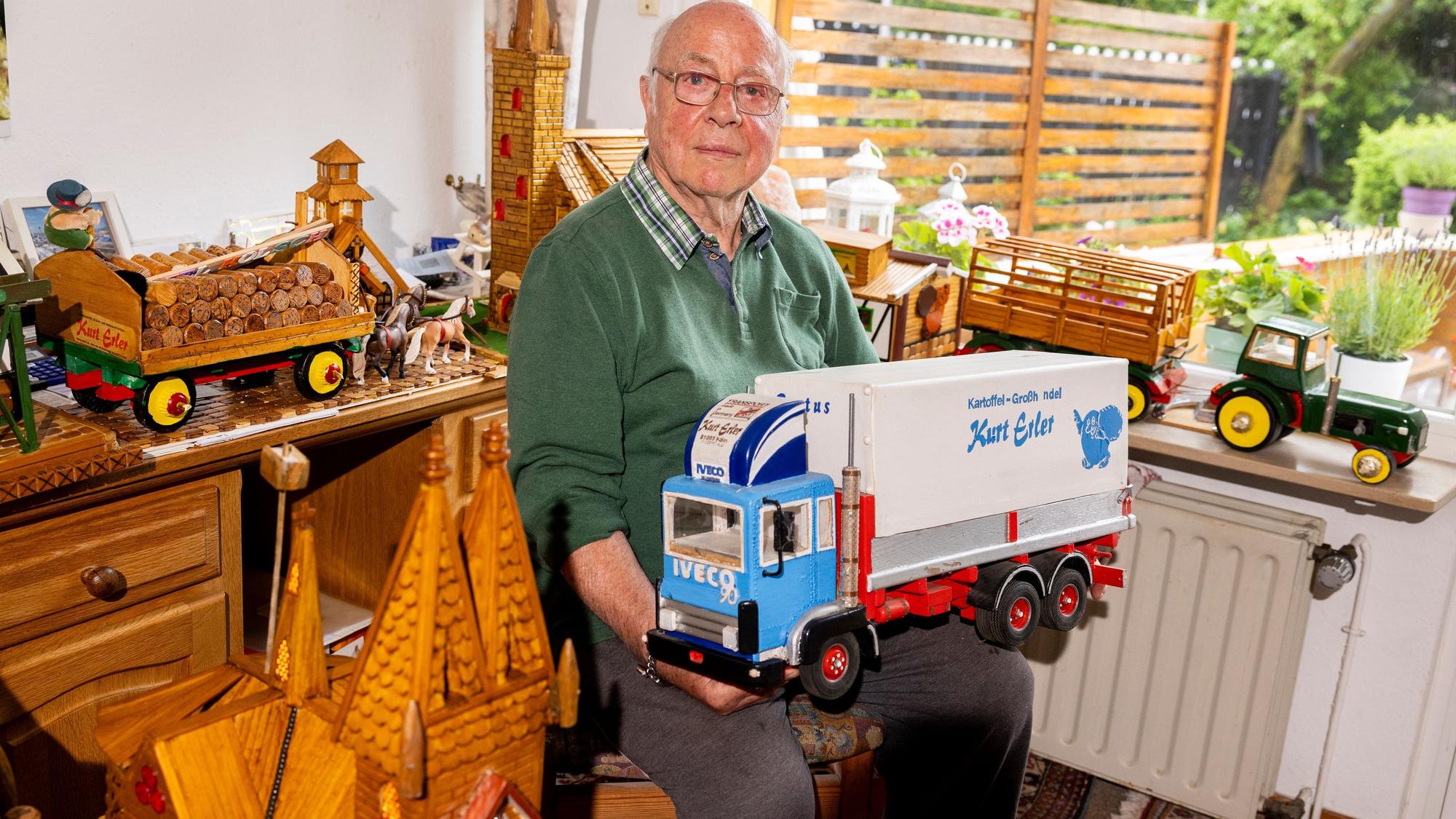 Kurt Erler (88) mit dem Modell seines Lastwagens und den vielen Holzmodellen, die er gebaut hat.