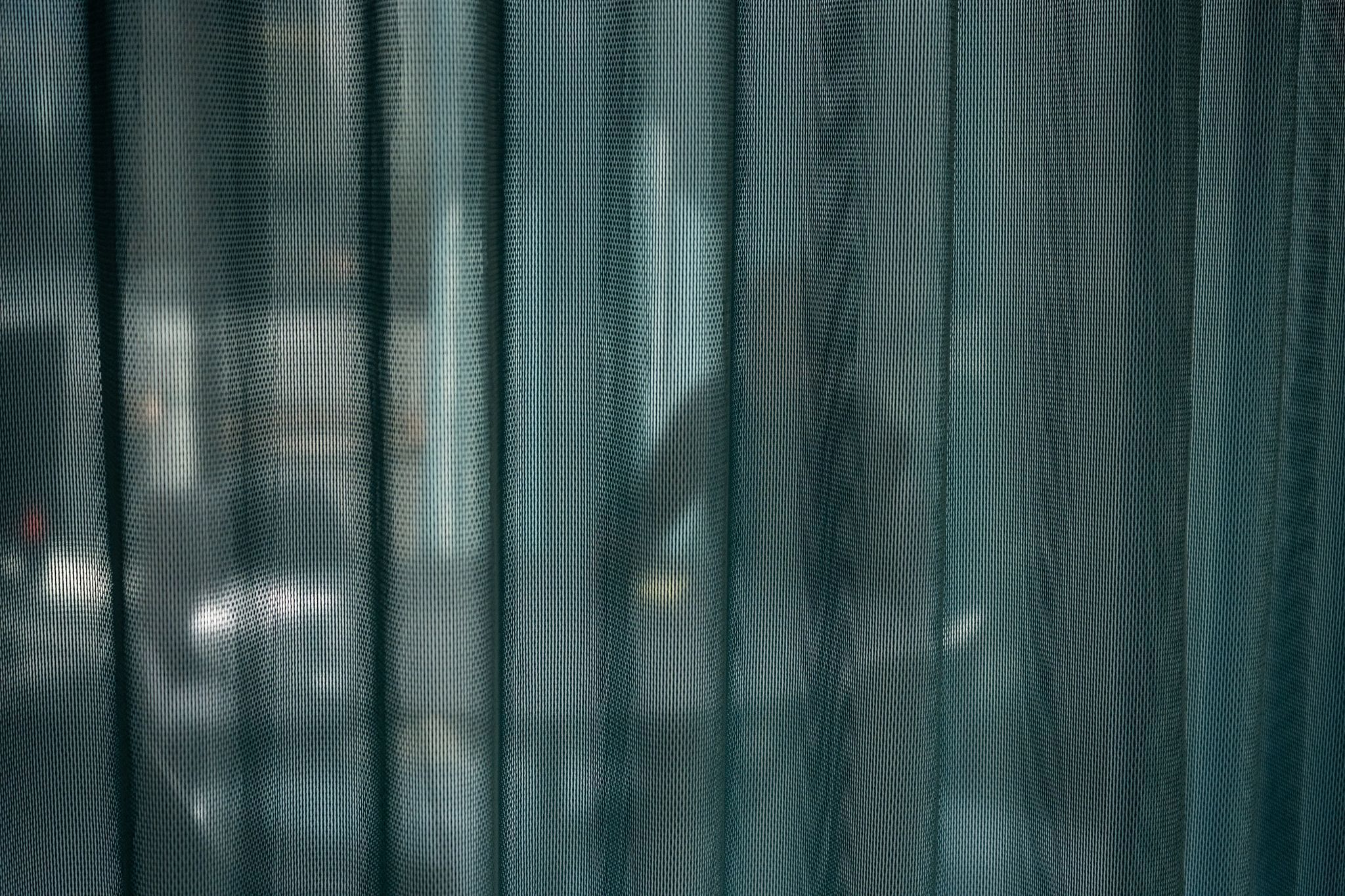 Ein Mann sitzt in einem Büro hinter einem Vorhang