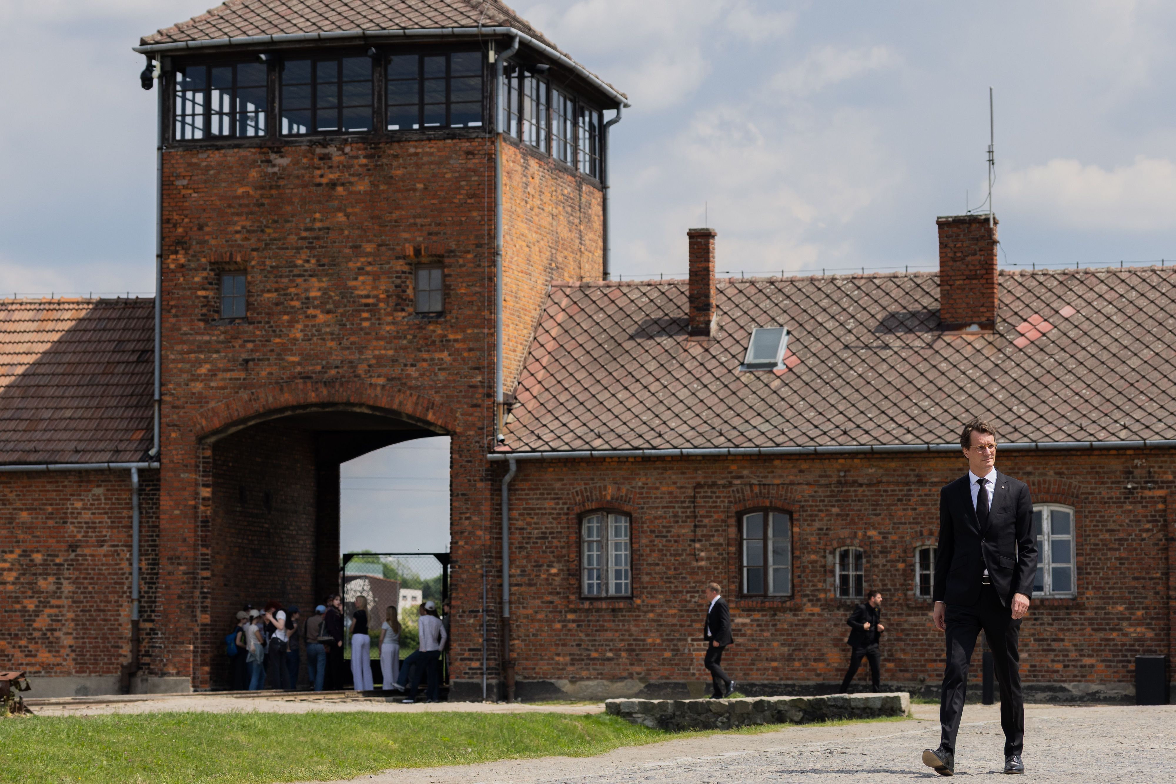Hendrik Wüst (CDU), Ministerpräsident von Nordrhein-Westfalen, betritt durch das Tor das ehemalige Konzentrations- und Vernichtungslager Auschwitz-Birkenau (Auschwitz II).
