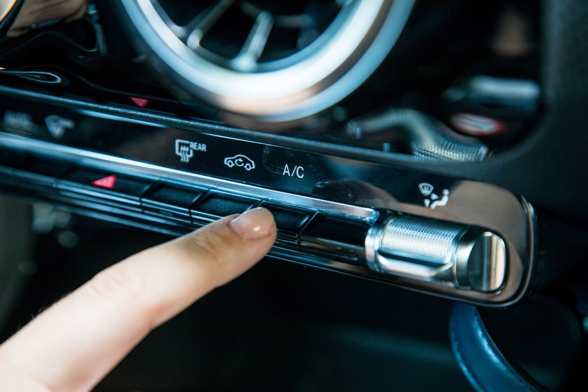 Eine Frau aktiviert die Klimaanlage in einem Auto