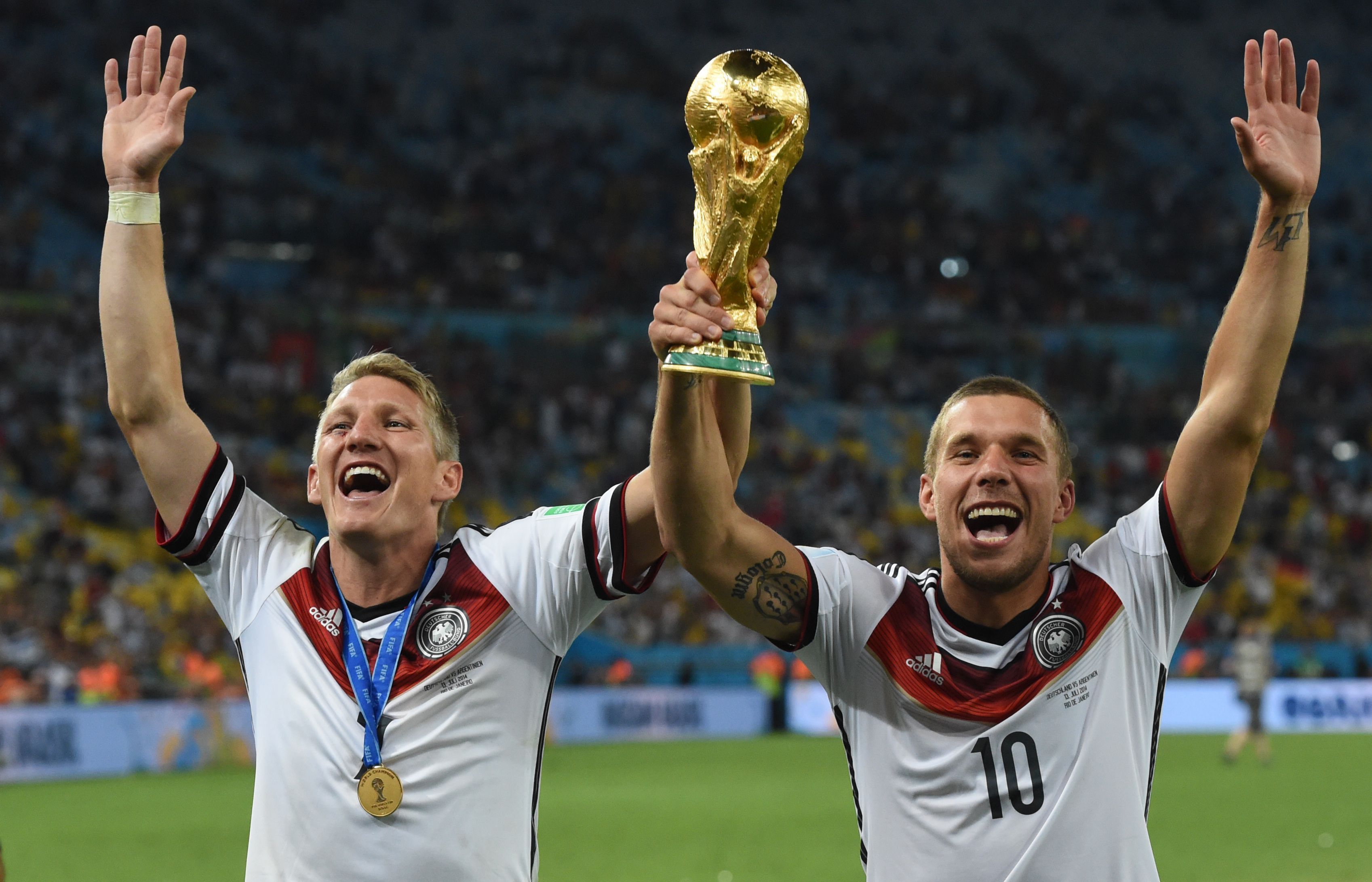 Rio De Janeiro: Bastian Schweinsteiger (l) und Lukas Podolski jubeln nach dem Sieg bei der FIFA Weltmeisterschaft 2014 mit dem Pokal.
