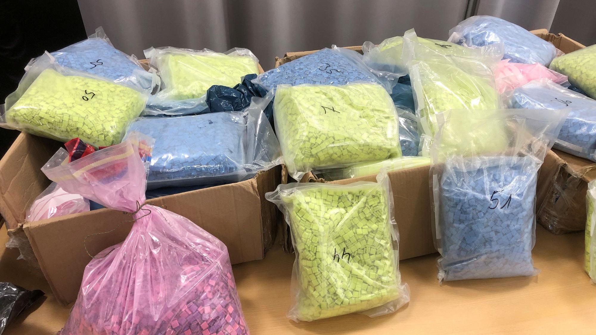 Säcke mit Ecstasy-Tabletten liegen auf einem Tisch.