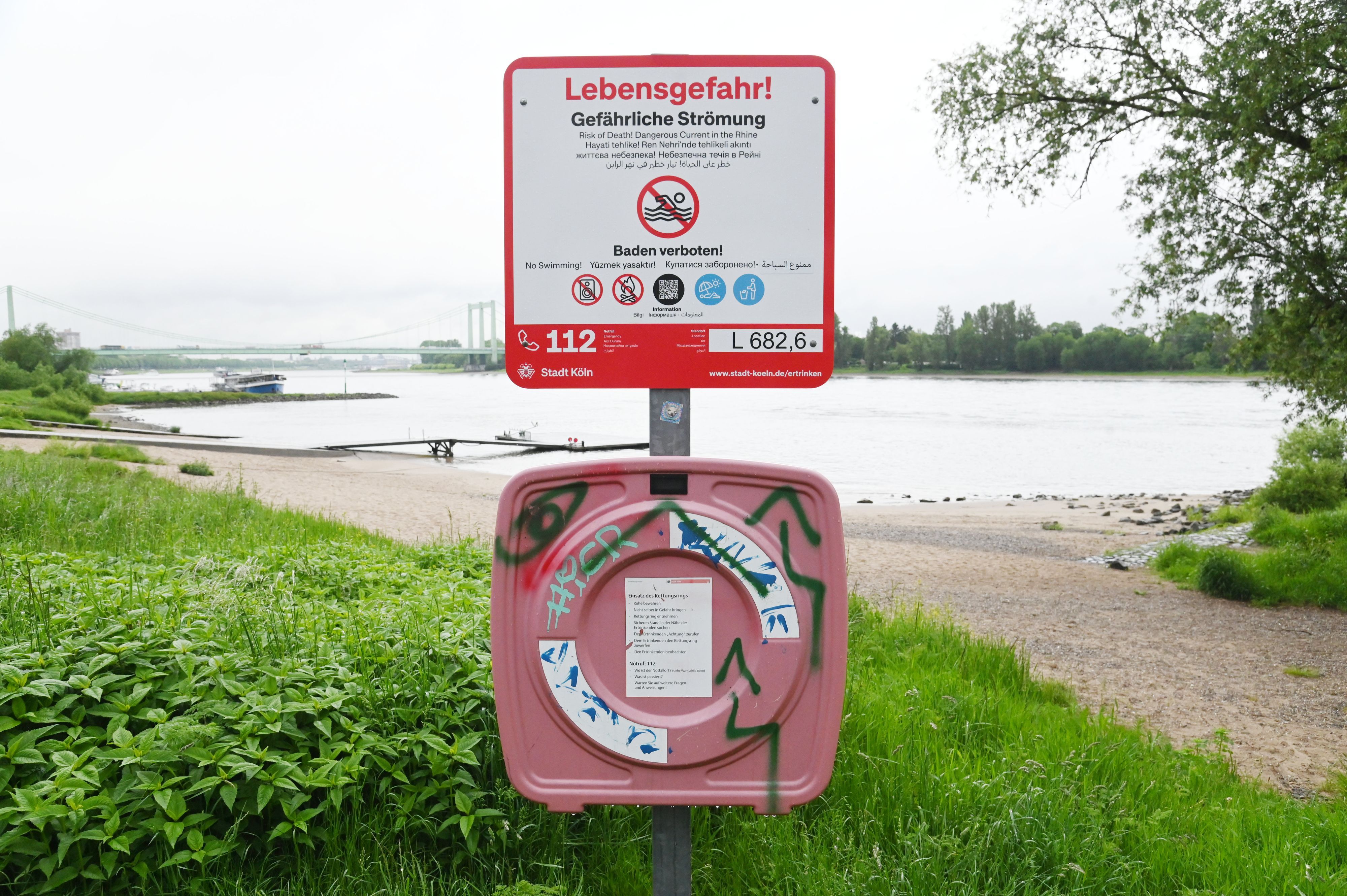 20.05.2026 Köln. Am Rheinufer stehen neue Schilder, die auf das Badeverbot im Rhein hinweisen. Die Stadt hatte das Schwimmen im Fluss im letzten Jahr verboten. Während auf den Tafeln bislang nur ein Warnezeichen abgebildet war, zeigt es nun Verbotszeichen. Rodenkirchen. Foto: Alexander Schwaiger