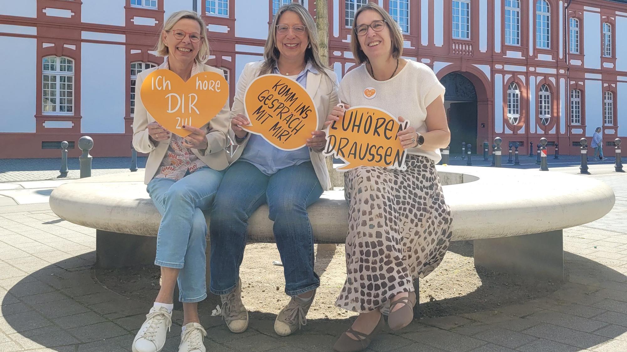 Drei Frauen sitzen auf einer Bank.