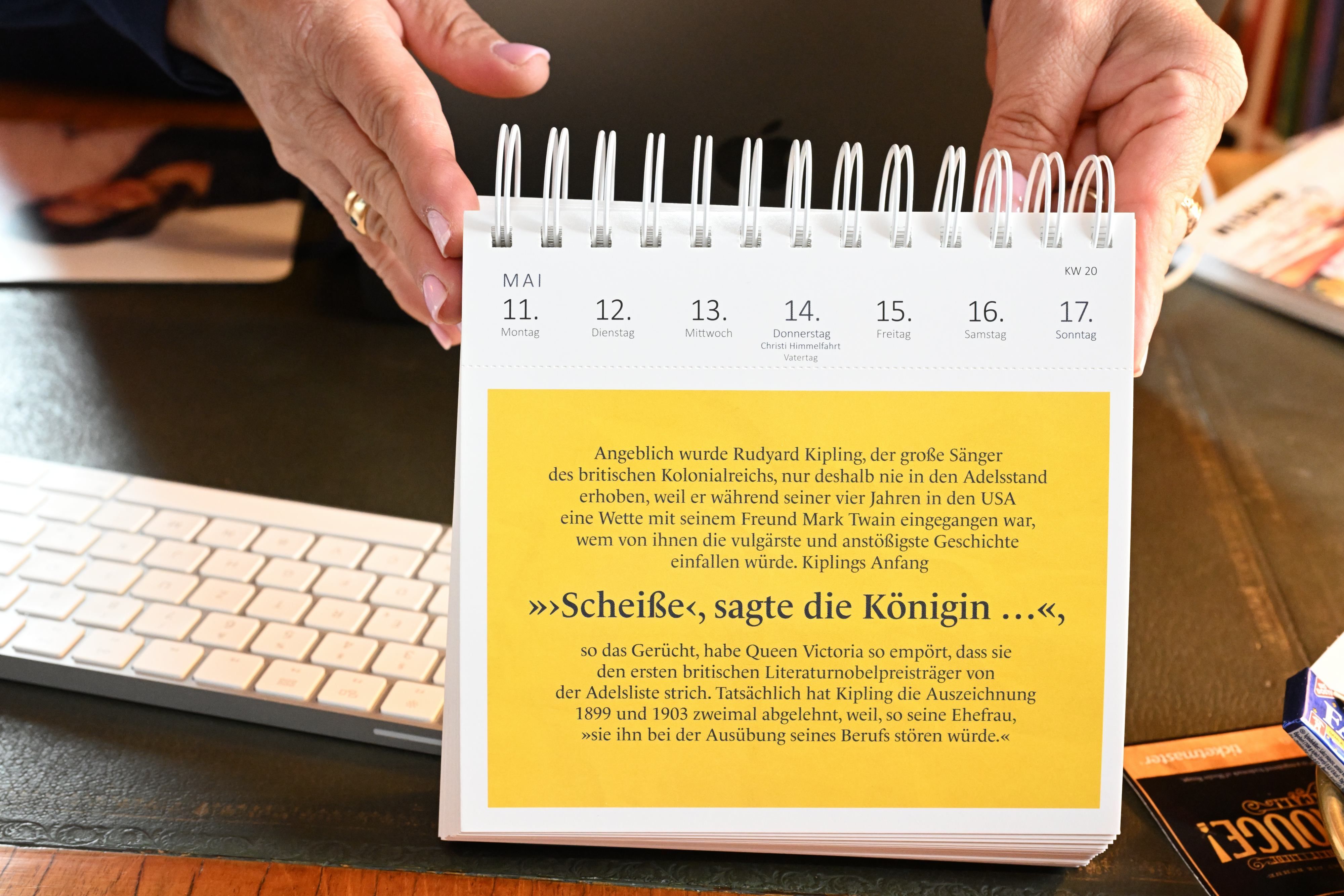 Ein gelbes Kalenderblatt mit dem Zitat: "Scheiße, sagte die Königin...".