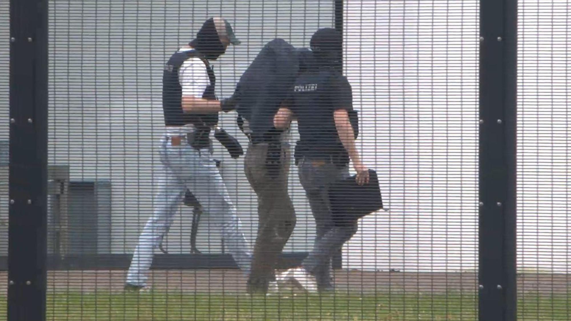 20.05.2026, Baden-Württemberg, Karlsruhe: Ein Mann, bei dem es sich vermutlich um einen mutmaßliche chinesischer Spion wird zur Haftvorführung an den Bundesgerichtshof (BGH) gebracht. Die Bundesanwaltschaft hat in München zwei mutmaßliche chinesische Spione festnehmen lassen. Das Ehepaar mit deutscher Staatsangehörigkeit soll für einen chinesischen Geheimdienst Kontakte zu zahlreichen Wissenschaftlern an deutschen Hochschulen und Forschungseinrichtungen aufgenommen haben, wie die Karlsruher Behörde mitteilte. Foto: René Priebe/PR-Video /dpa - ACHTUNG: Kennzeichen wurde aus rechtlichen Gründen gepixelt +++ dpa-Bildfunk +++