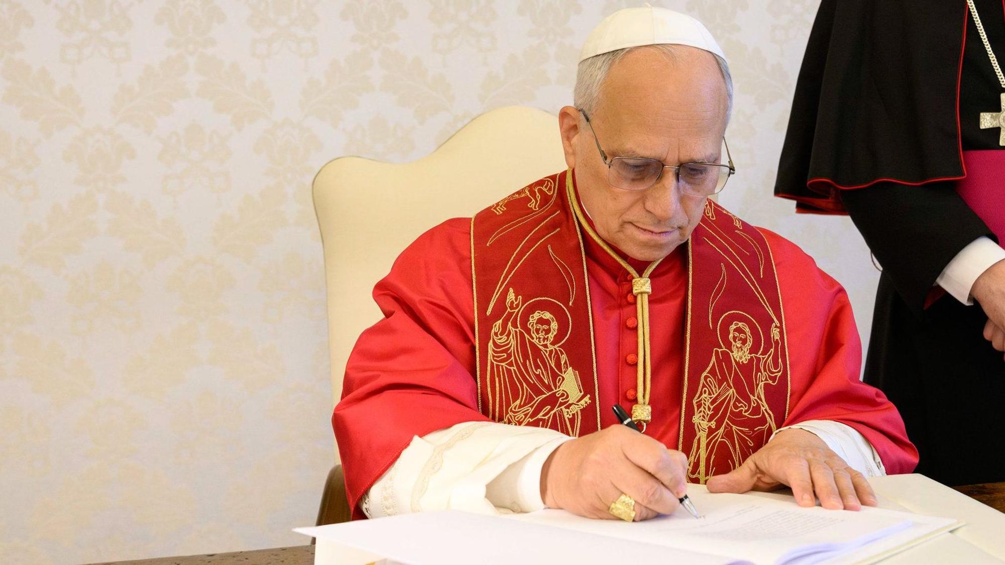 Papst Leo XIV. unterzeichnet die Enzyklika "Magnifica Humanitas - über die Bewahrung des Menschen im Zeitalter der Künstlichen Intelligenz" am 25. Mai 2026 im Vatikan. Rechts im Bild: Erzbischof Paolo Rudelli, Substitut für Allgemeine Angelegenheiten des Staatssekretariats. Weitere Berichterstattung bei KNA.