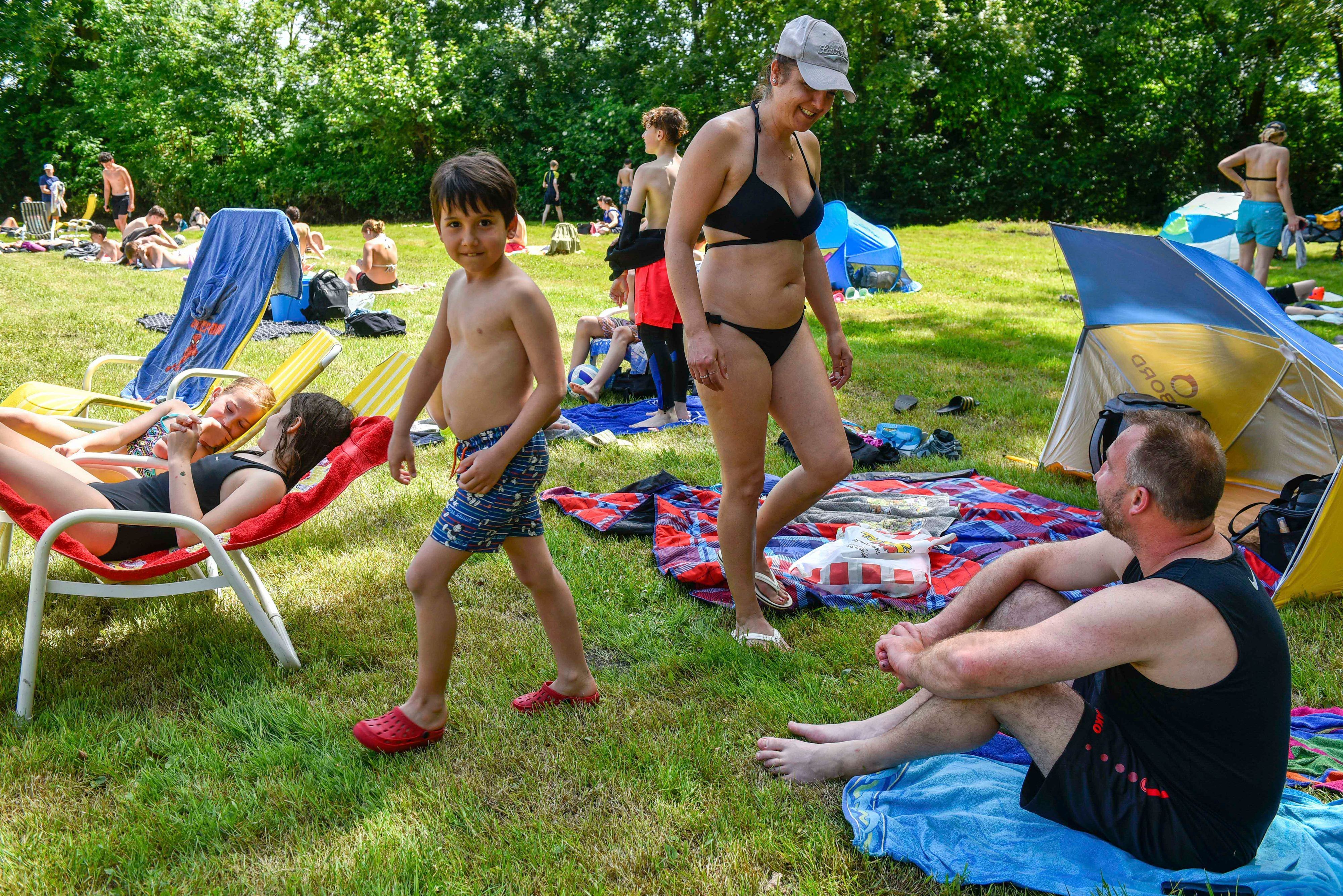 Das Foto zeigt eine Familie auf der Wiese am Freibad.