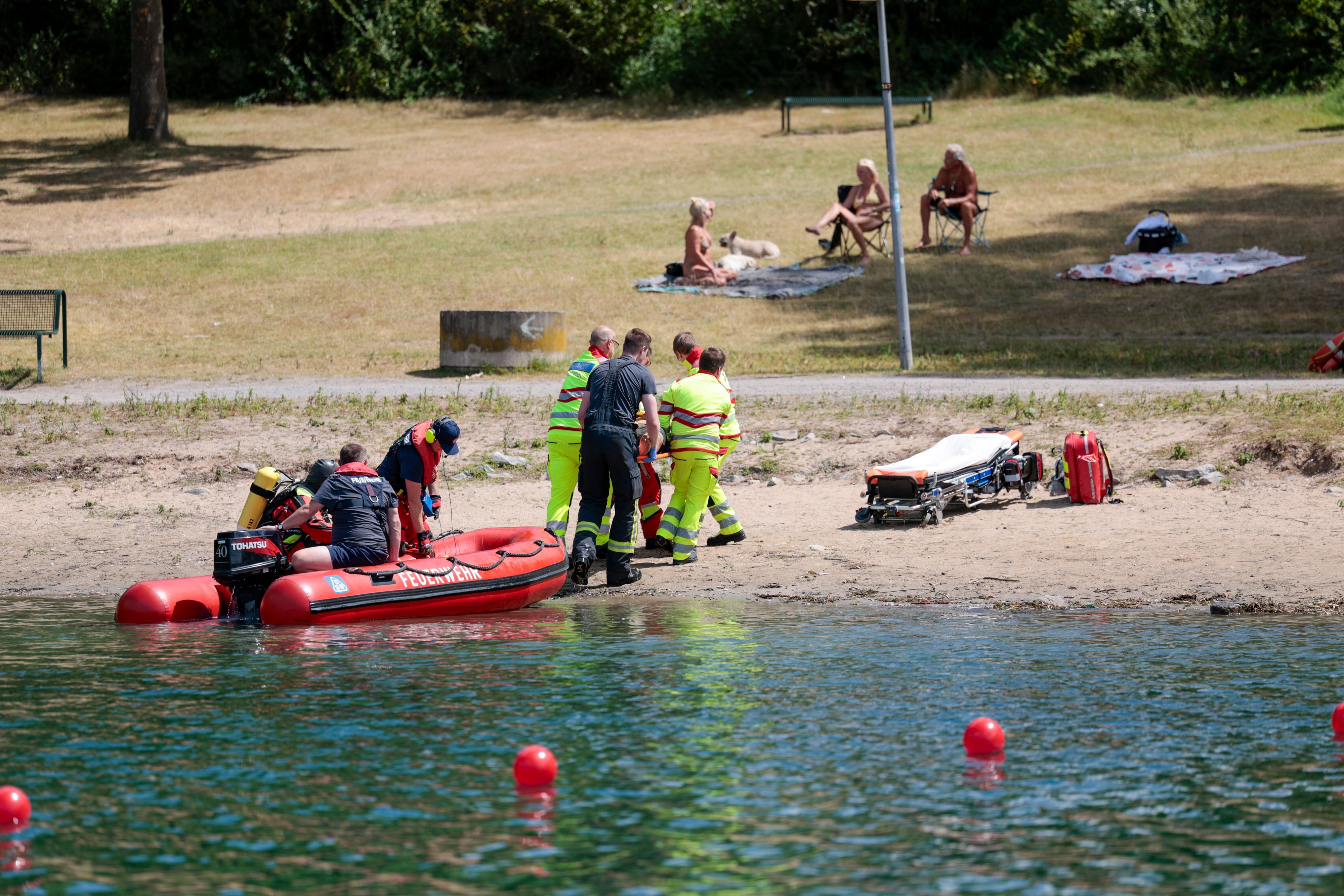 Einsatzkräfte der Berufsfeuerwehr Köln, der DLRG (Deutsche Lebens-Rettungs-Gesellschaft) und von den Rettungstauchern (Wasserrettung) simulieren die Rettung einer Person aus dem Fühlinger See, um dabei auch über die Risiken in Gewässern und beim Schwimmen aufzuklären. (Archivbild)