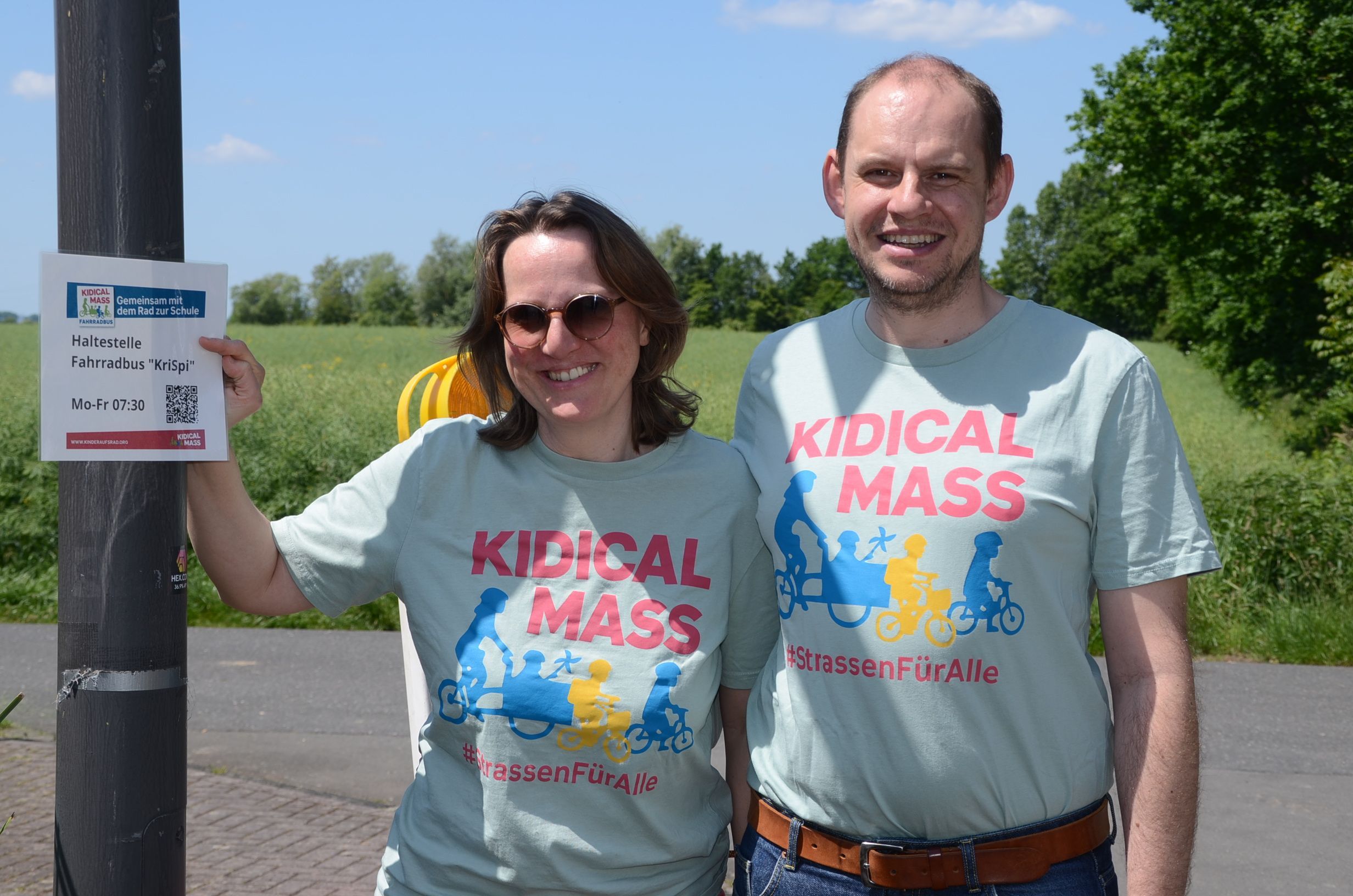 Ein Mann und eine Frau in hellblauen T-Shirts mit der Aufschrift Kidical Mass.