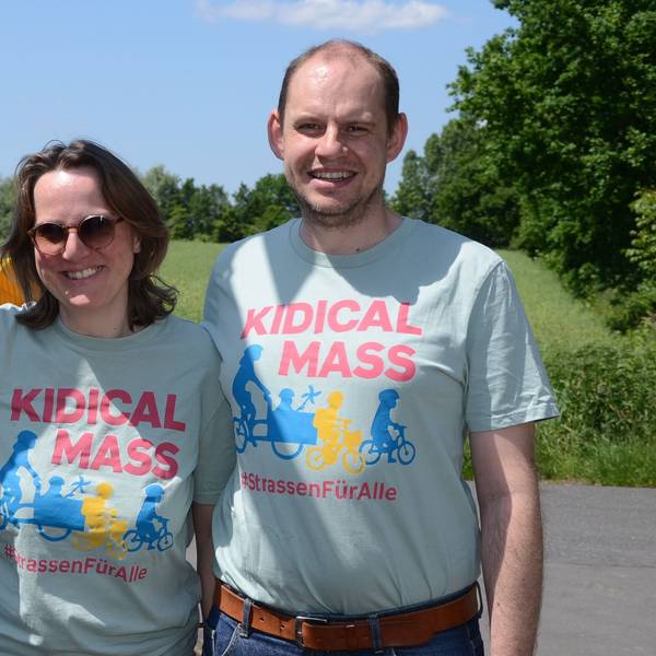 Ein Mann und eine Frau in hellblauen T-Shirts mit der Aufschrift Kidical Mass.