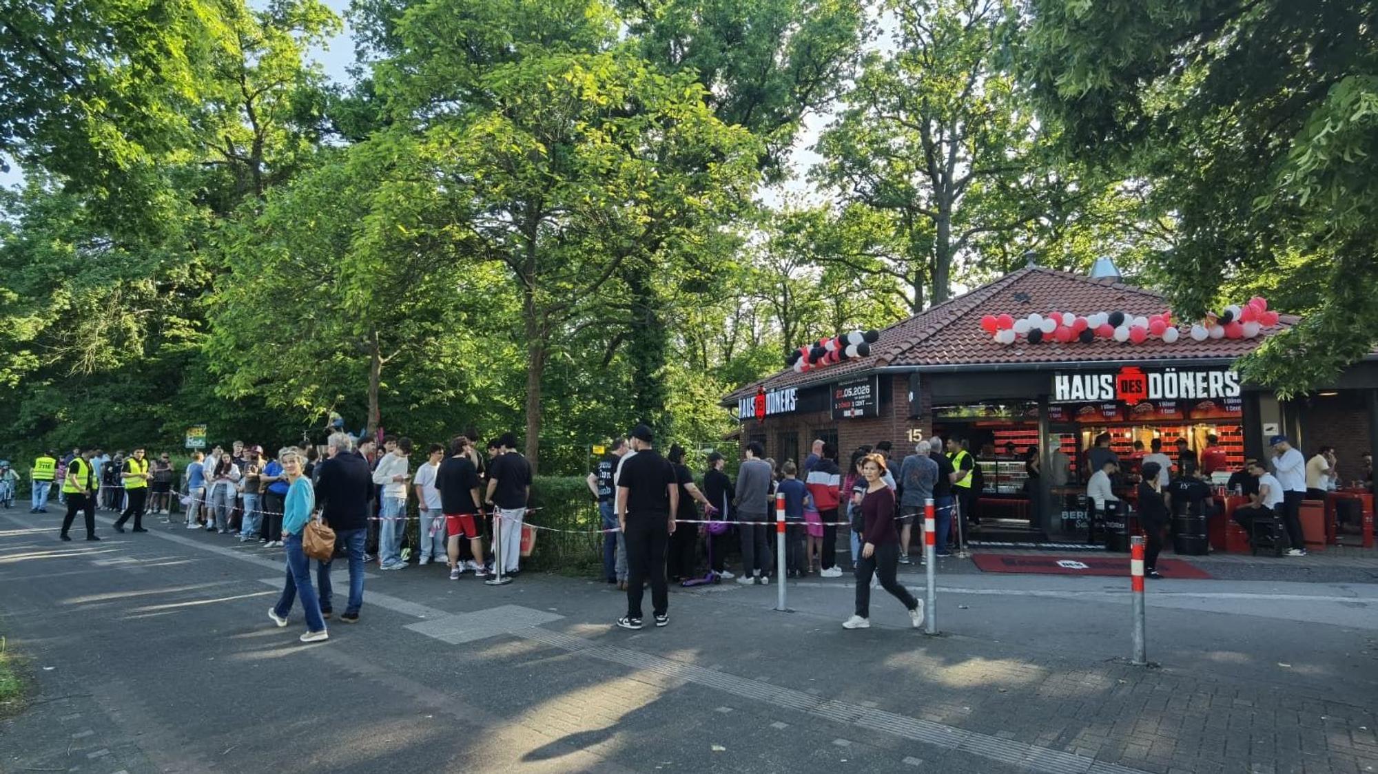 Zu sehen ist eine Menschenschlange vor der Filiale eines Döner-Imbiss'.