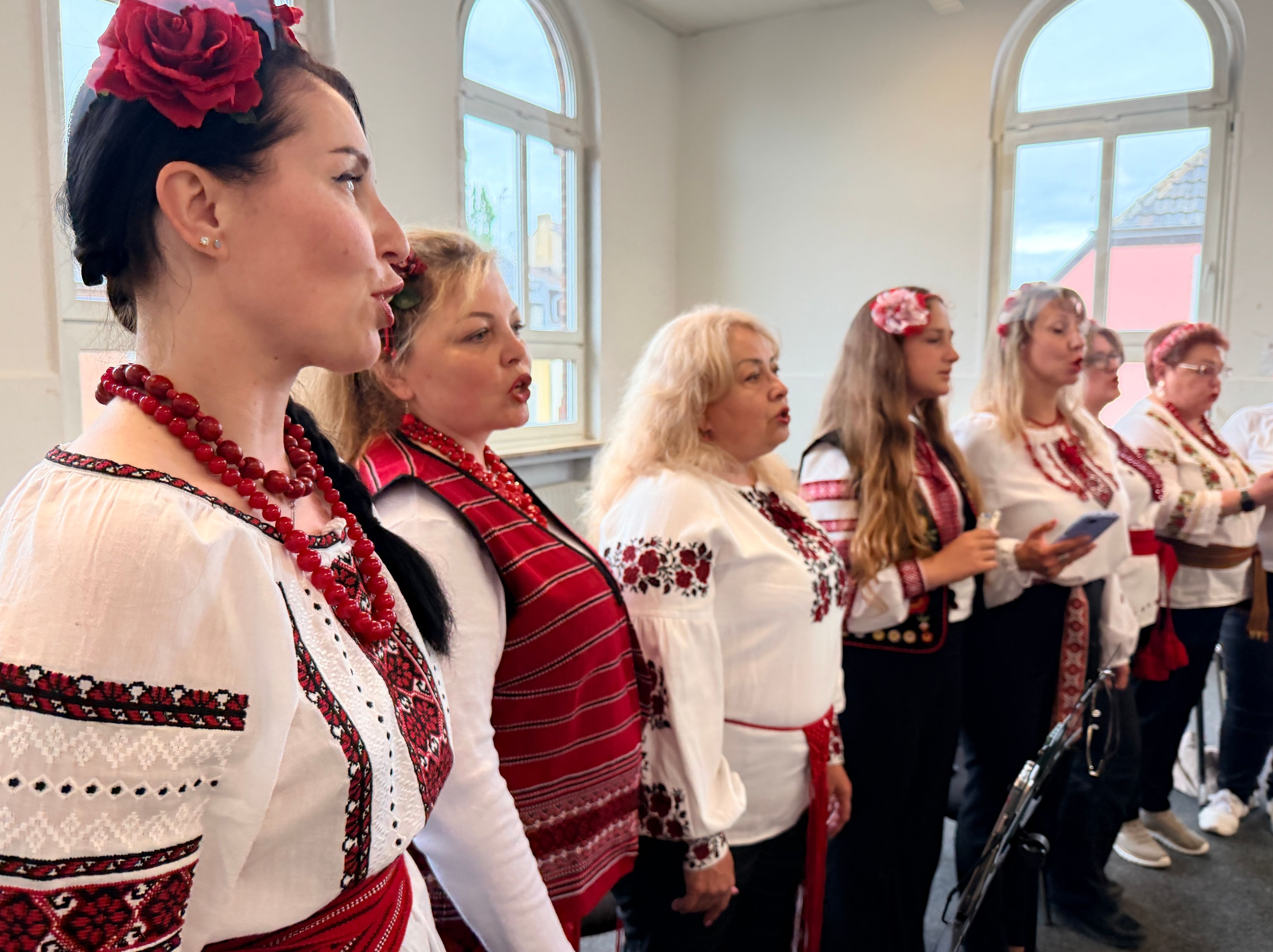 Die Sängerinnen stehen nebeneinander. Sie tragen die bestickten folkloristischen Kleider der Ukraine.