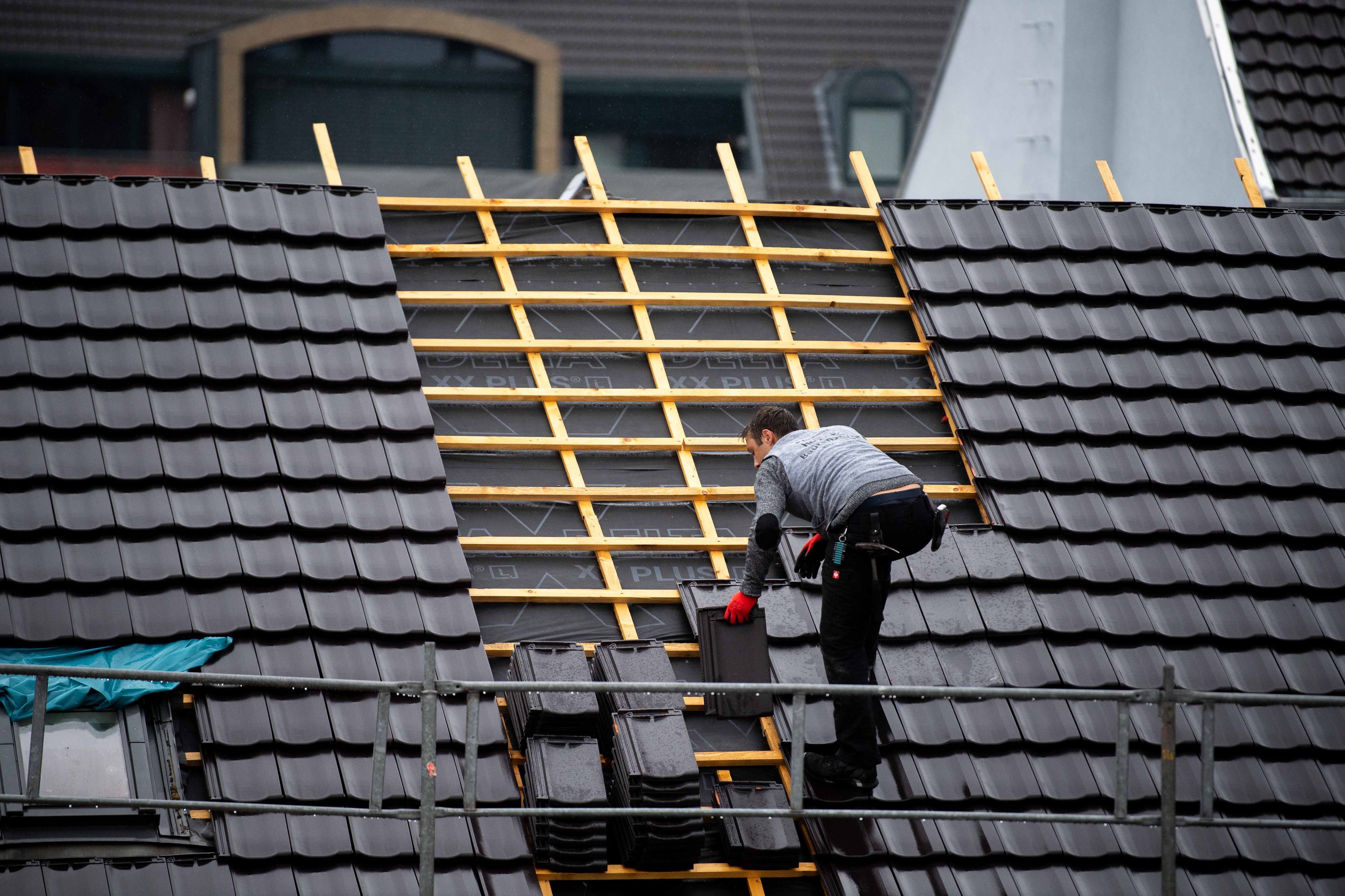 Ein Dachdecker deckt im Regen ein Dach in der Euskirchener Innenstadt.