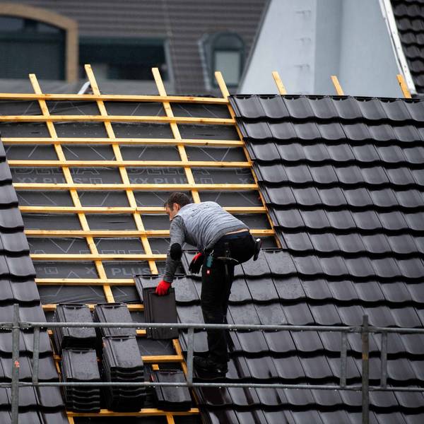 Ein Dachdecker deckt im Regen ein Dach in der Euskirchener Innenstadt.