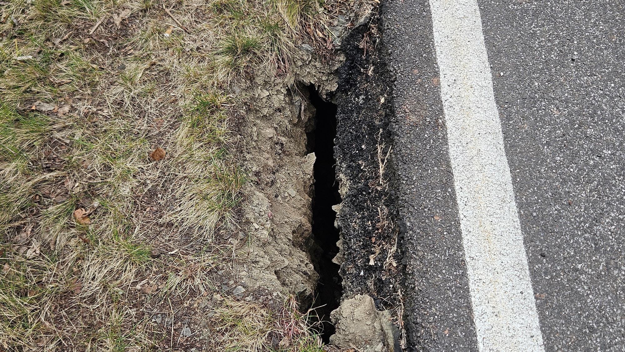 Das Foto zeigt einen Riss zwischen der Böschung und der Straße.