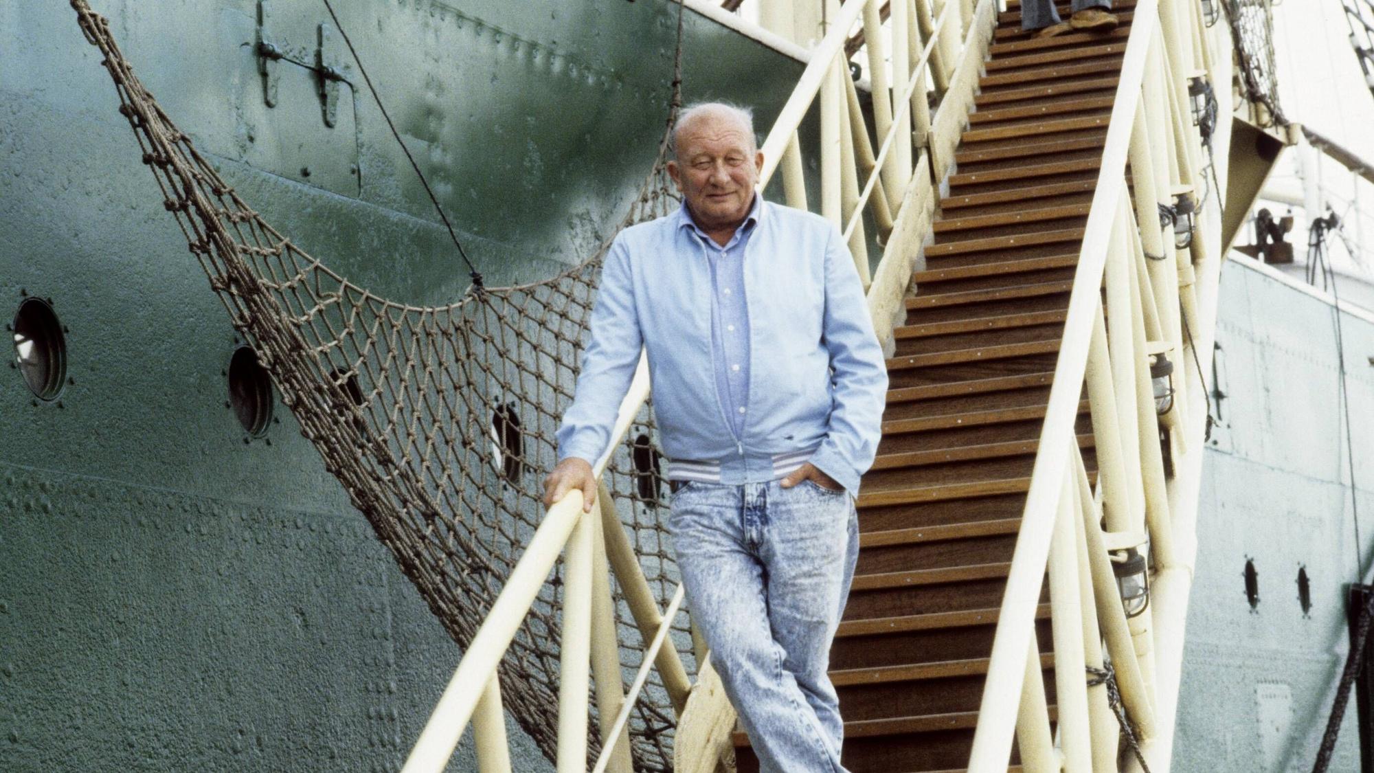 James Krüss steht vor einem Segelschiff