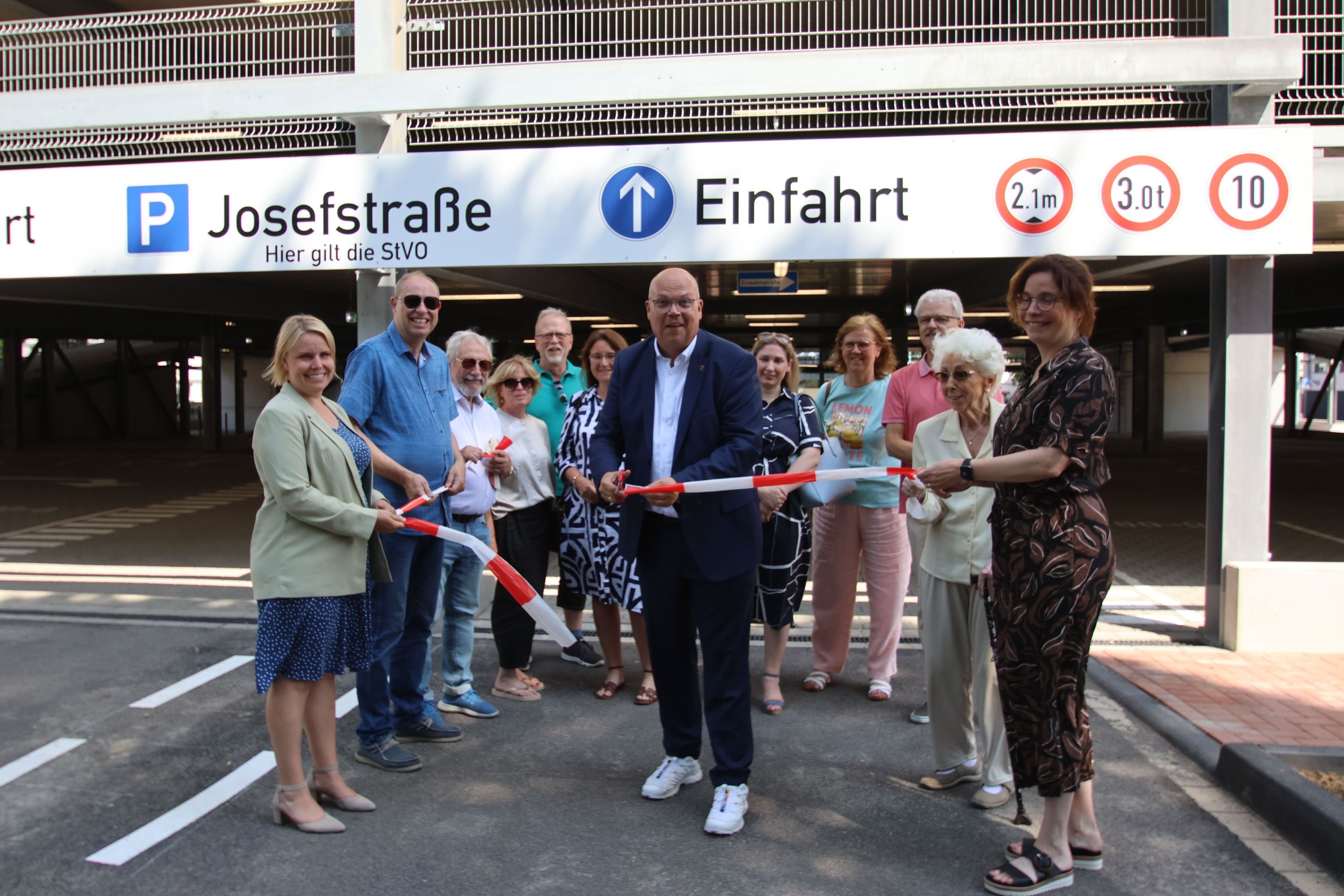 Im kleinen Rahmen gab Bürgermeister Uwe Tietz (M.) das neue Parkhaus an der Alte Straße durch den obligatorischen Scherenschnitt frei.