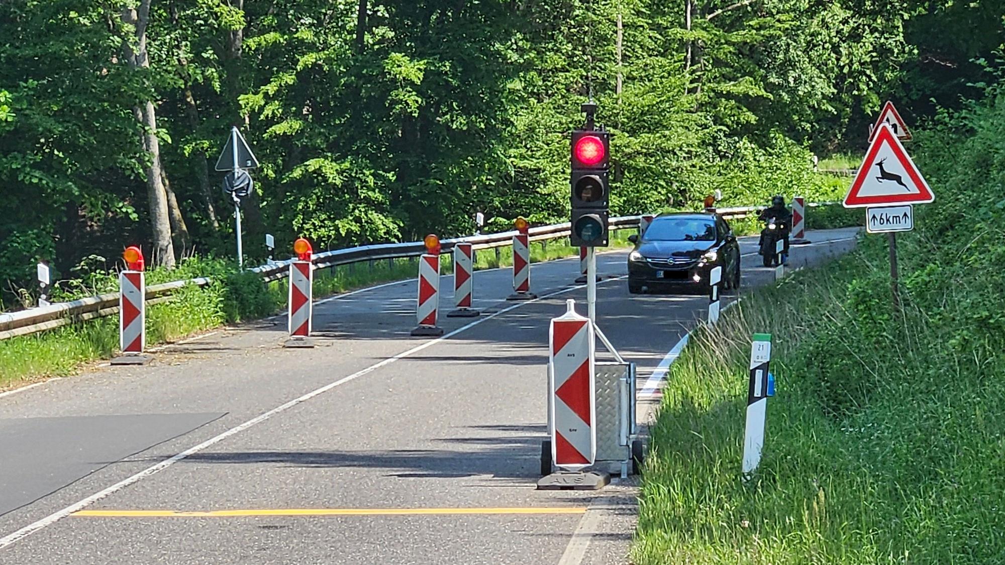 Blick auf die halbseitig gesperrte Straße und eine rote Ampel.