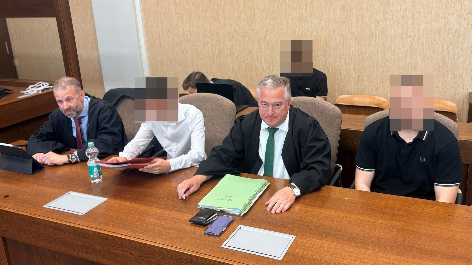 Die beschuldigten FC-Fans mit den Anwälten Tobias Westkamp (l.) und Lars Leininger im Amtsgericht.