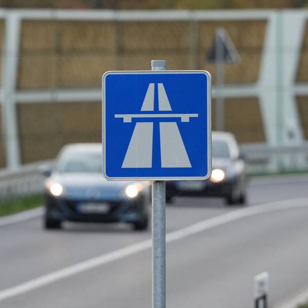 Das Foto zeigt ein Autobahn-Schild, im Hintergrund befinden sich Fahrzeuge.
