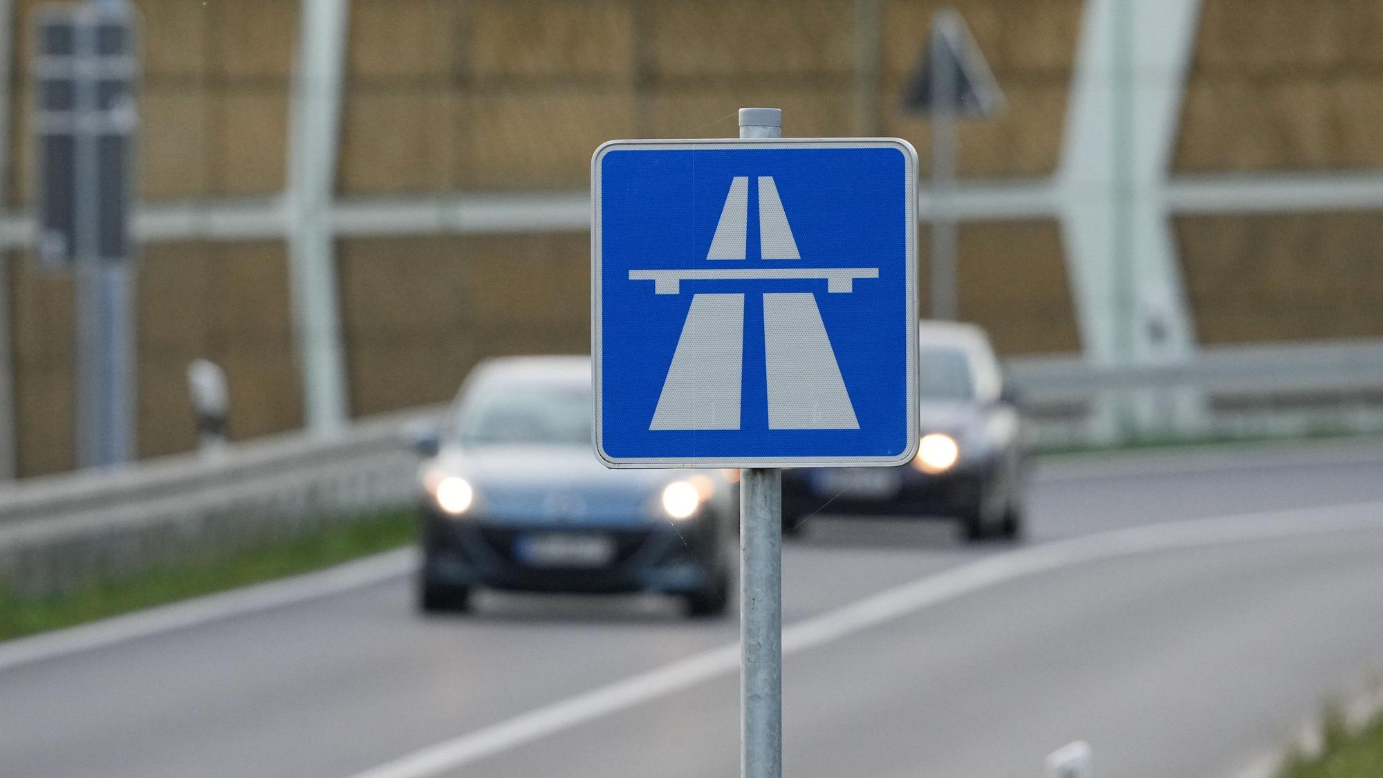 Das Foto zeigt ein Autobahn-Schild, im Hintergrund befinden sich Fahrzeuge.