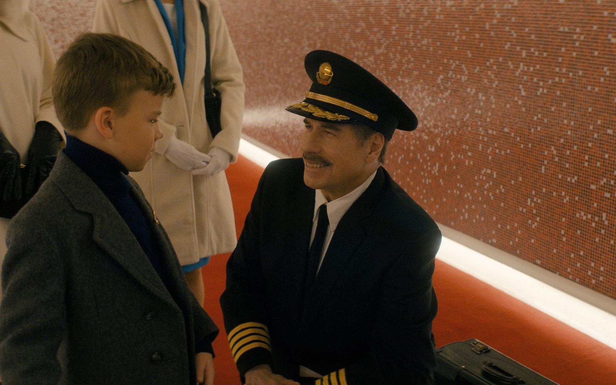 Der Pilot seines Jets von Denver nach Los Angeles (John Travolta, rechts) geht in Rente und wird am Flughafen dafür geehrt. So schafft es auch der achtjährige Jeff (Clark Shotwell) ins Rampenlicht von Los Angeles. Es gibt schlechtere Starts für ein Leben in Kalifornien. (Bild: Apple TV)