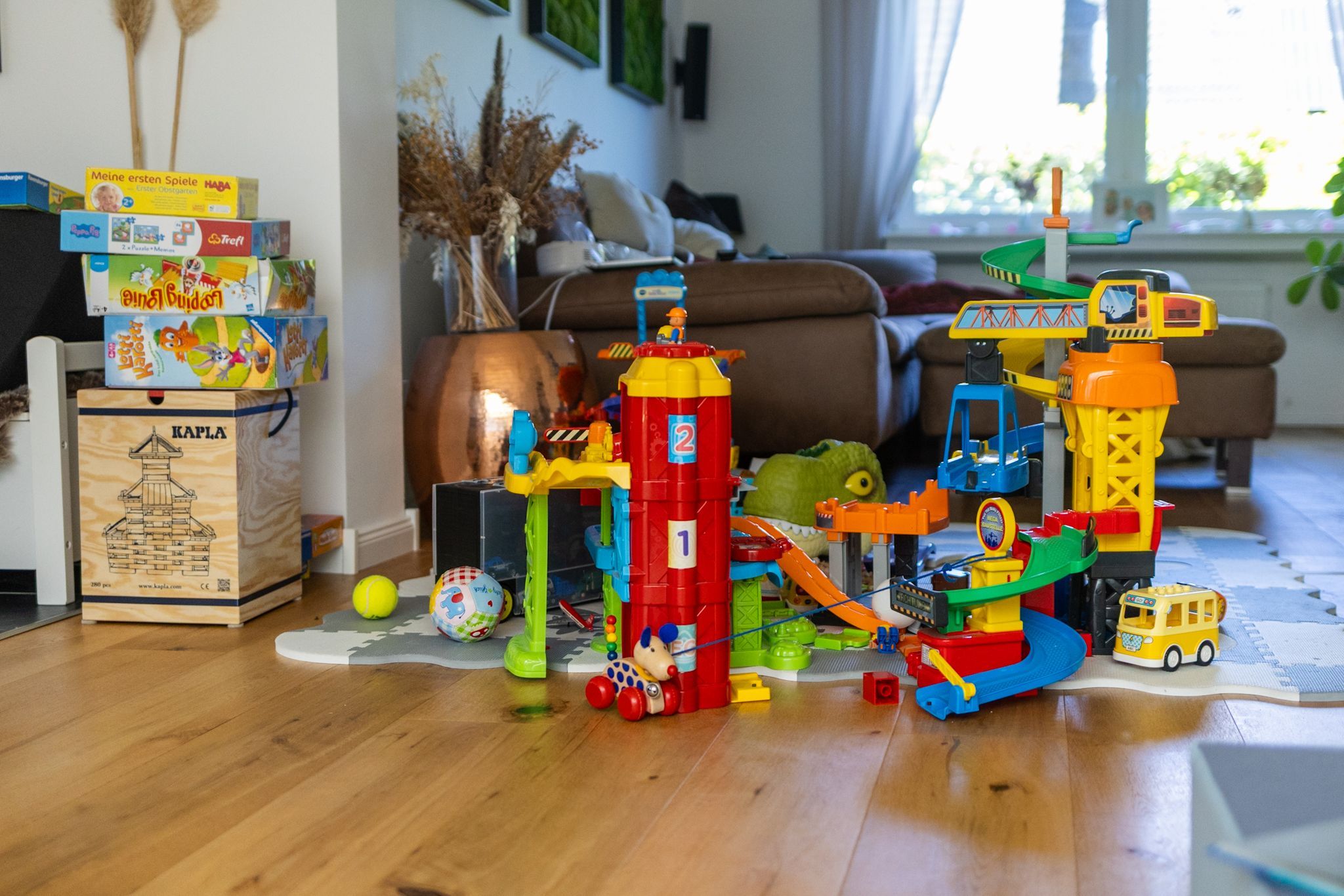Blick ins Wohnzimmer: Links stapeln sich Kinderspiele, rechts bunte Bauklötze.
