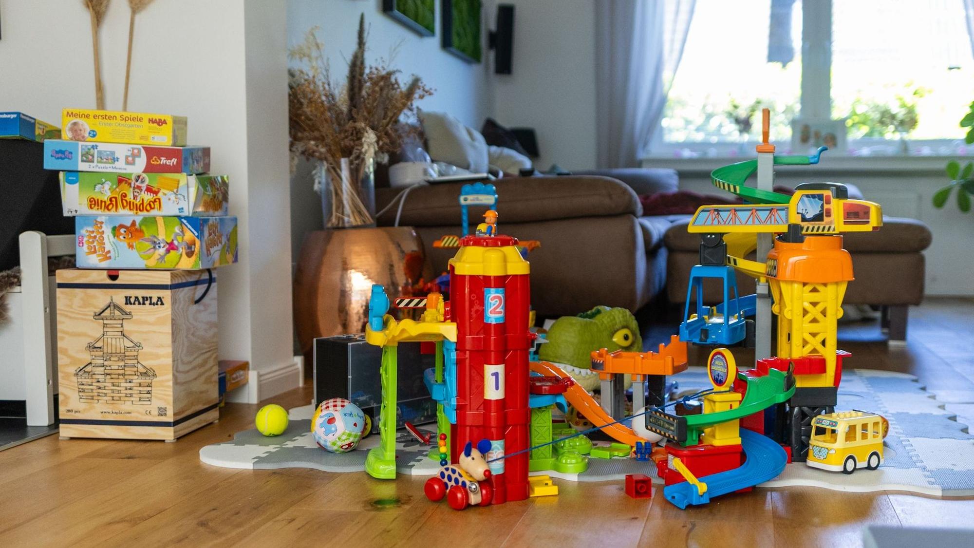 Blick ins Wohnzimmer: Links stapeln sich Kinderspiele, rechts bunte Bauklötze.