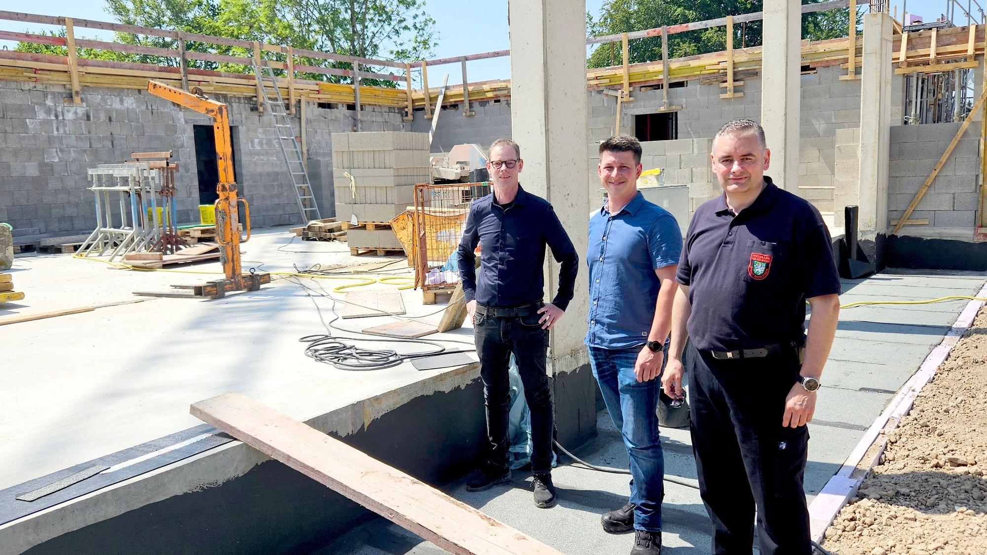 Die drei Genannten stehen nebeneinander vor dem Neubau.