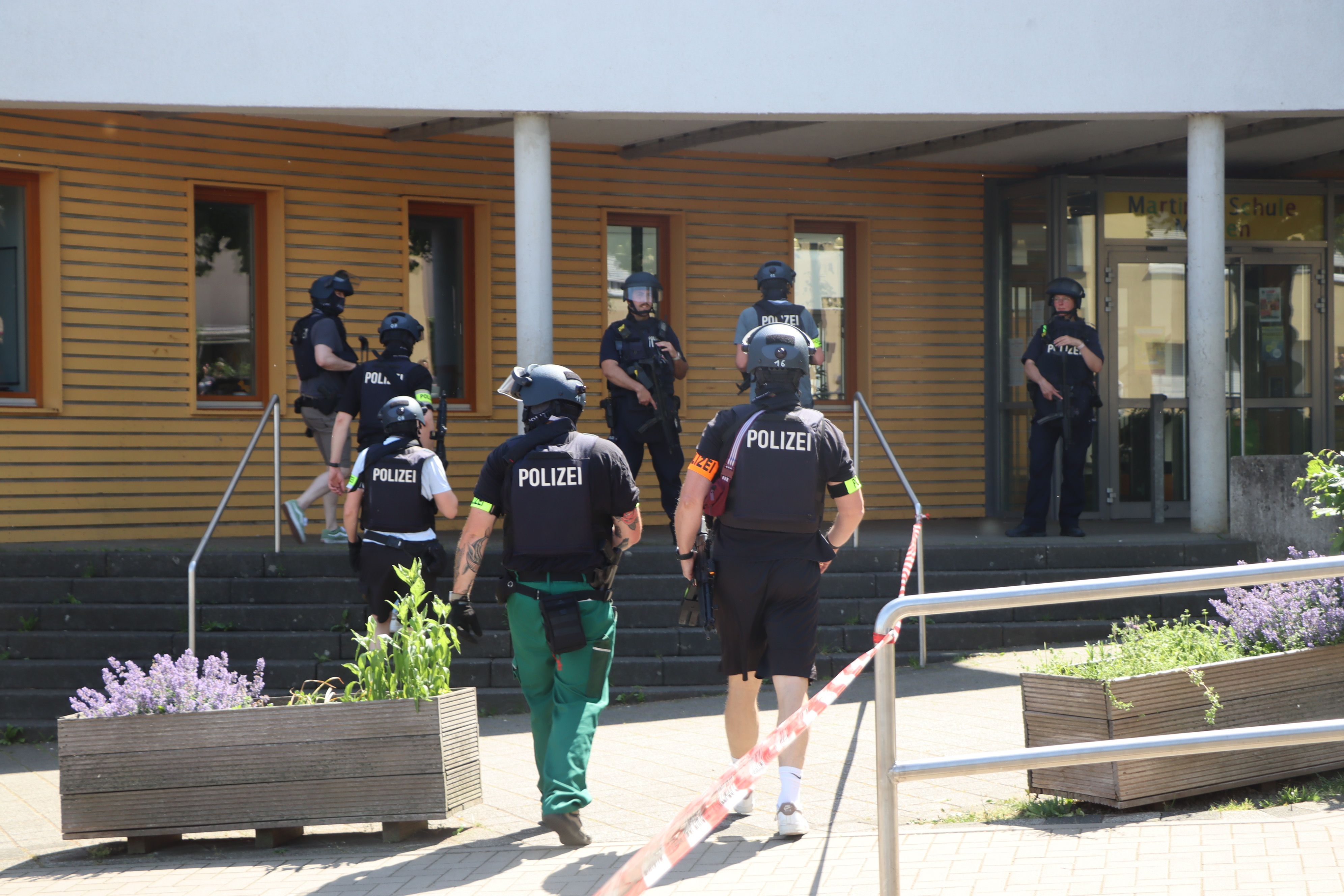 Vor der Heinrich-Böll-Gesamtschule in Merten positionierten sich Polizisten mit Waffen im Anschlag und durchsuchten das Gelände.
