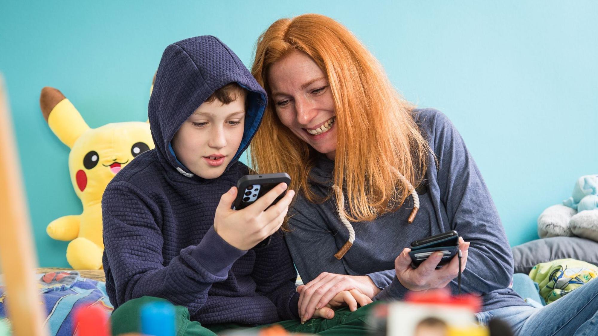 Mutter und Sohn mit Smartphones