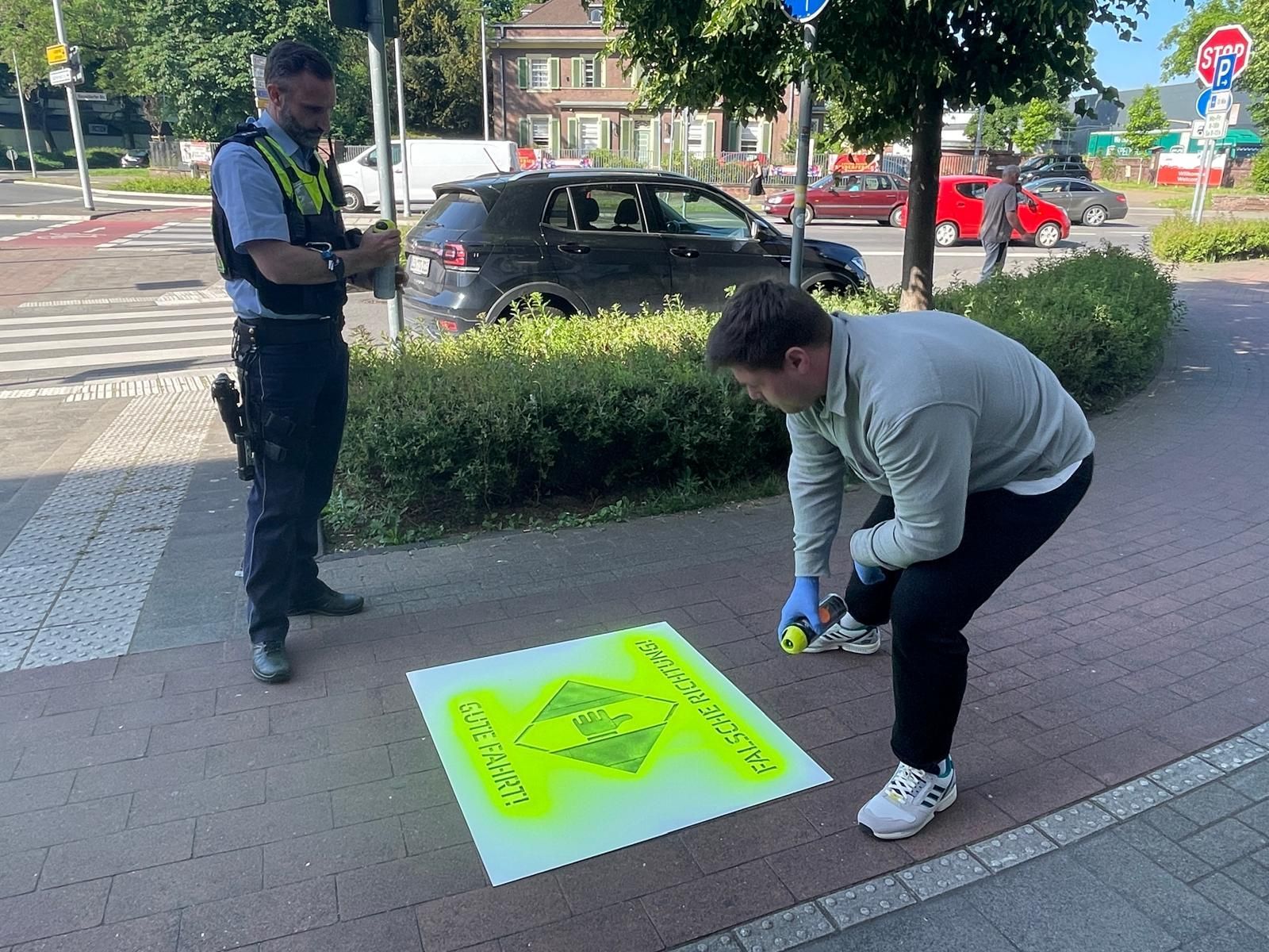Polizeihauptkommissar Matthias Blasius und Tobias Scheibe vom Fachbereich Mobilität und Klimaschutz sprühen die Markierungen auf.