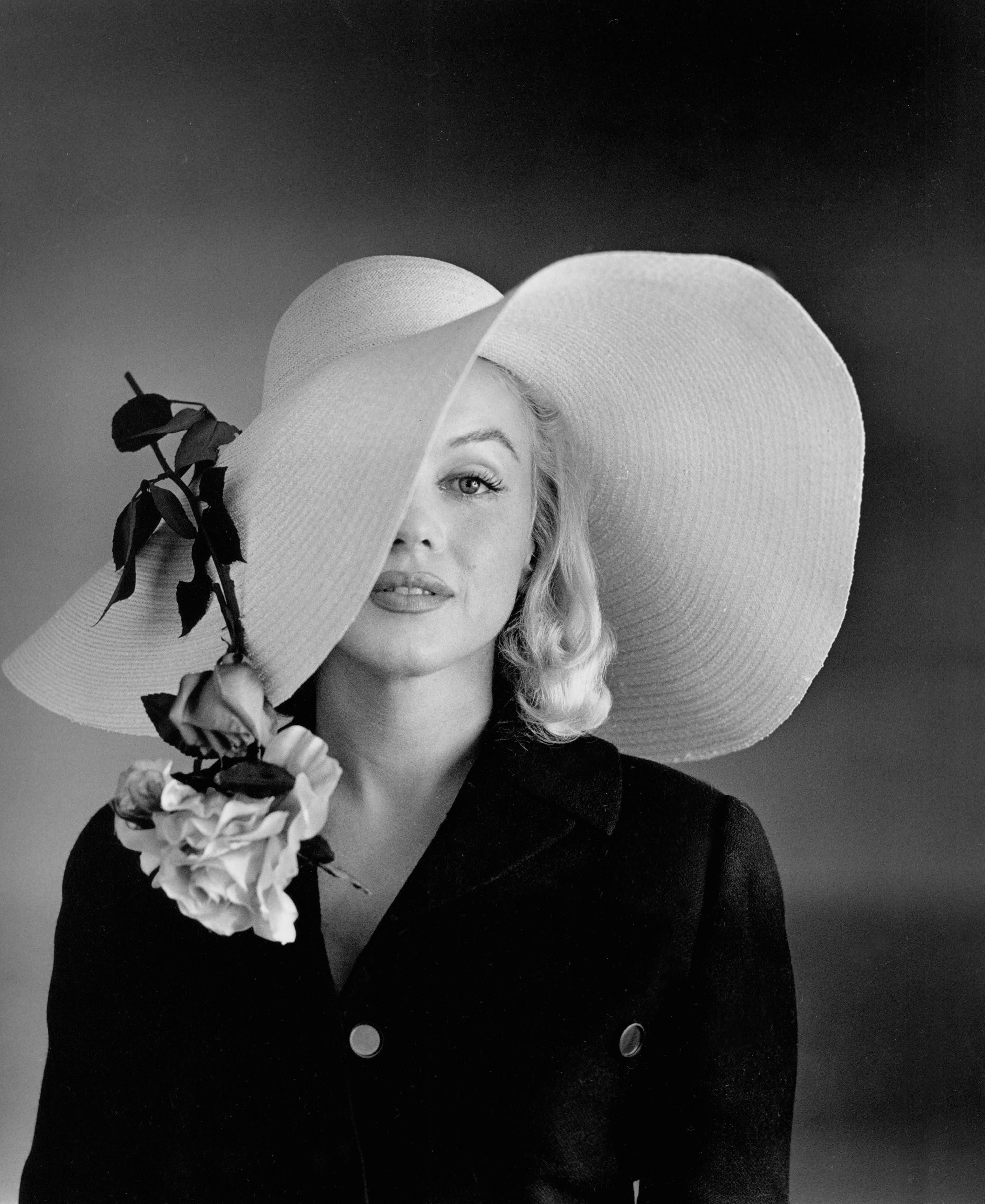 Marilyn Monroe trägt einen großen Hut.