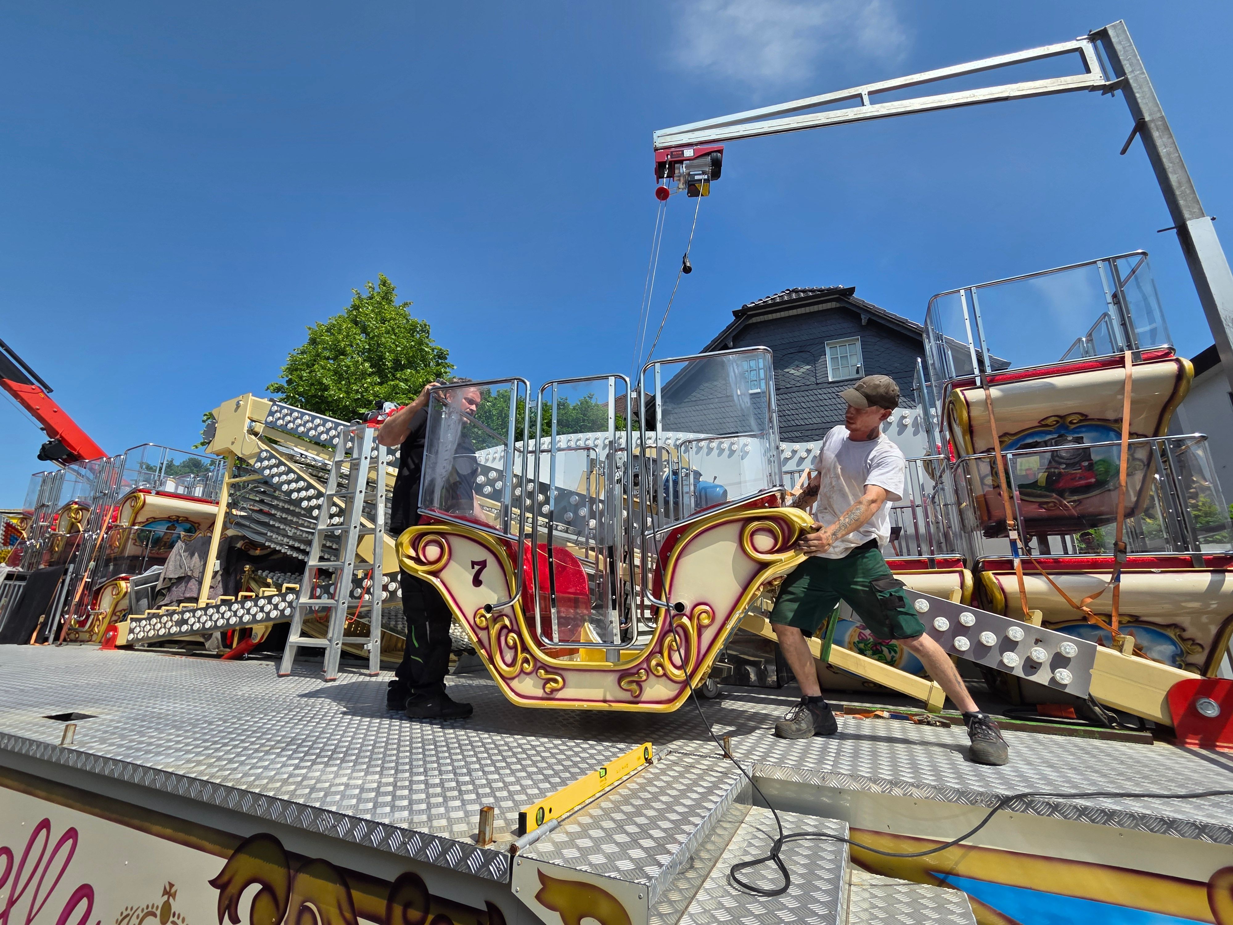 Christian Thiliant (links) und sein Mitarbeiter Michael Junge bereiten auf dem Kirmesplatz an der Hochstraße in Waldbröl die Gondeln des Riesenrad „Roue Belle“ für die spätere Montage vor.