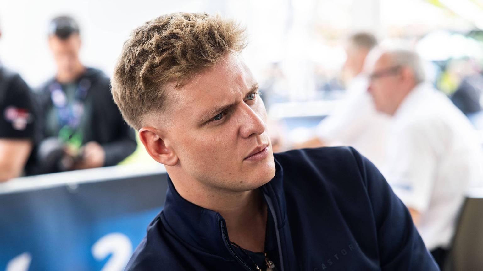 Mick Schumacher sitzt in der Boxengasse.