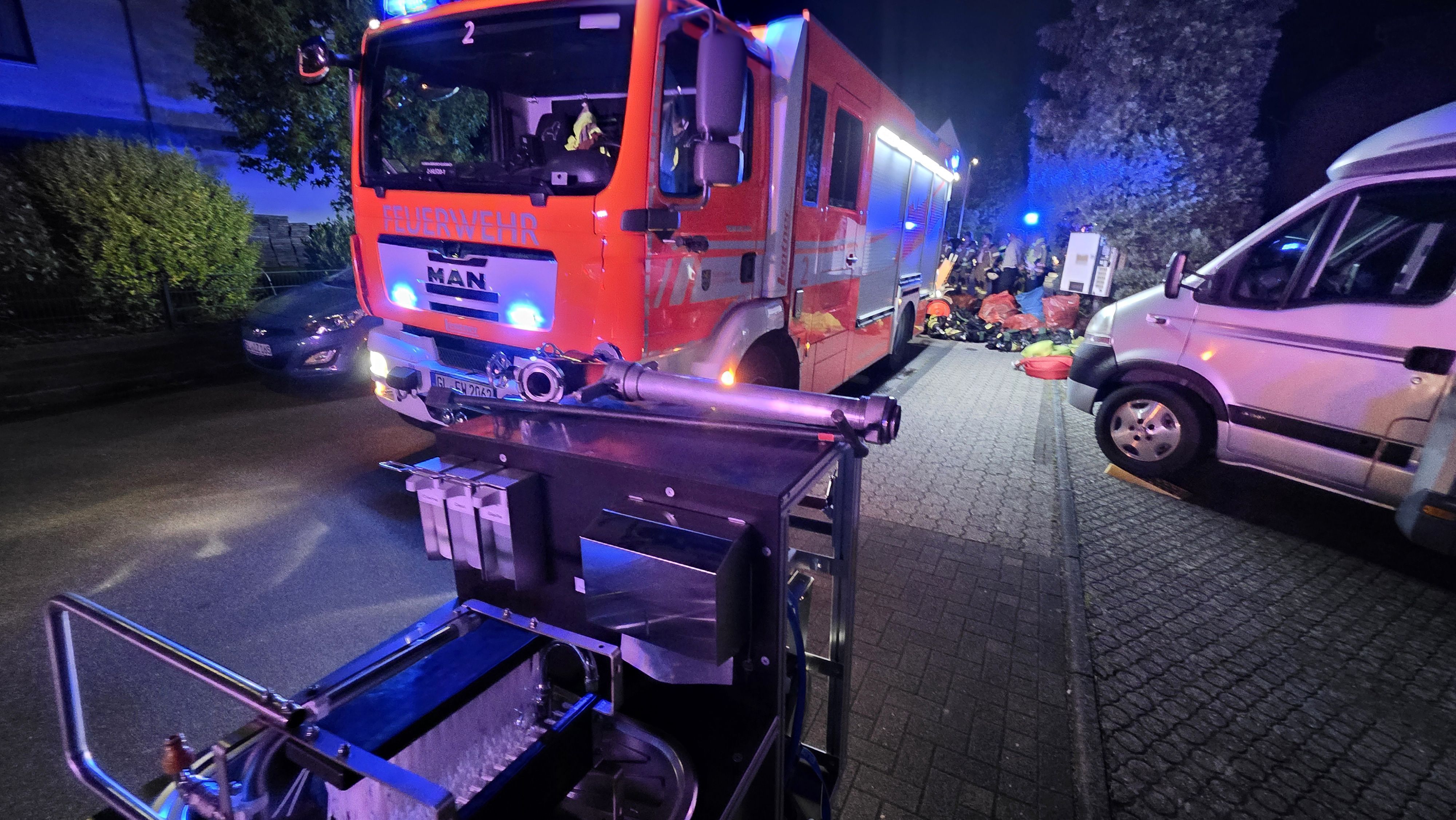 Ein Einsatzfahrzeug der Feuerwehr steht mit Blaulicht auf einer Straße in Bergisch Gladbach-Kippekausen.
