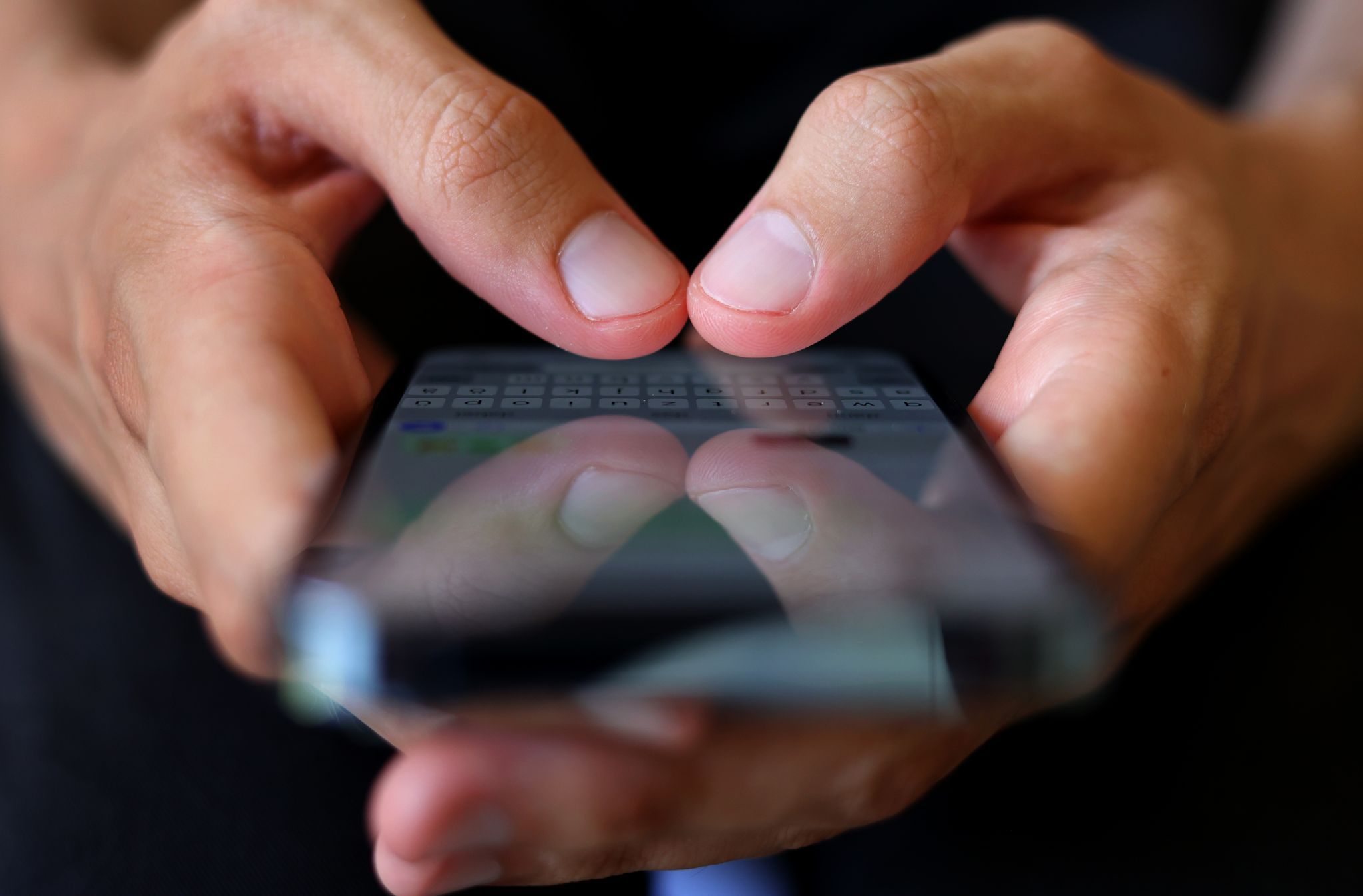 Ein Mann tippt auf einem Smartphone