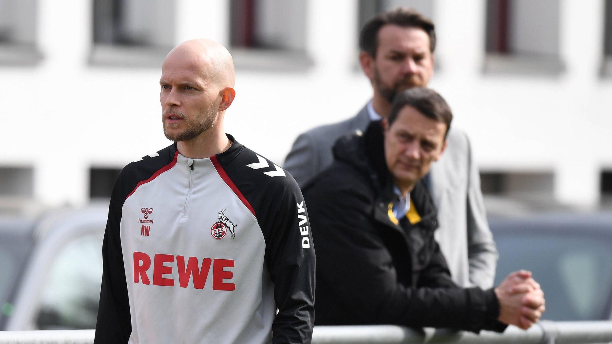 René Wagner auf dem Trainingsplatz, dahinter stehen Ulf Sobek und Thomas Kessler an der Bande.